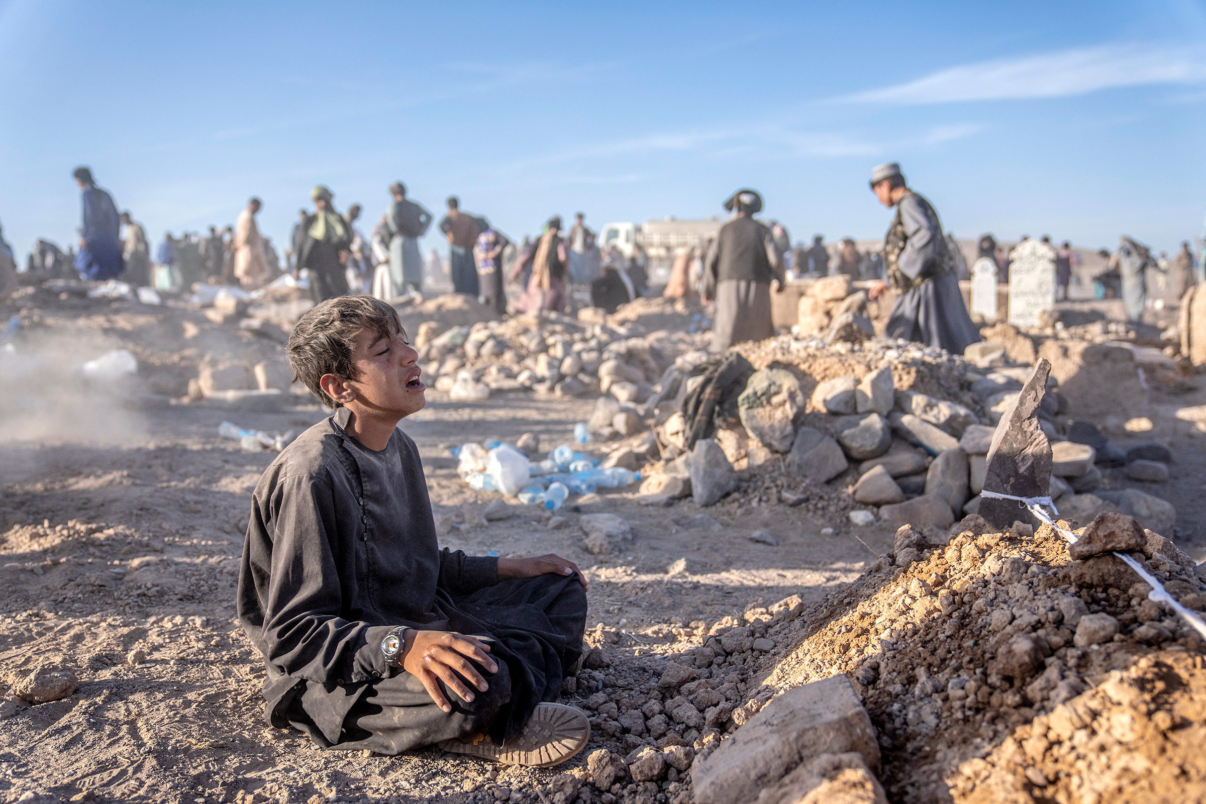 An Afghan boy mourns next to the grave of his little brother who died due to an earthquake, in Zenda Jan district in Herat province, Afghanistan, on Oct. 9.