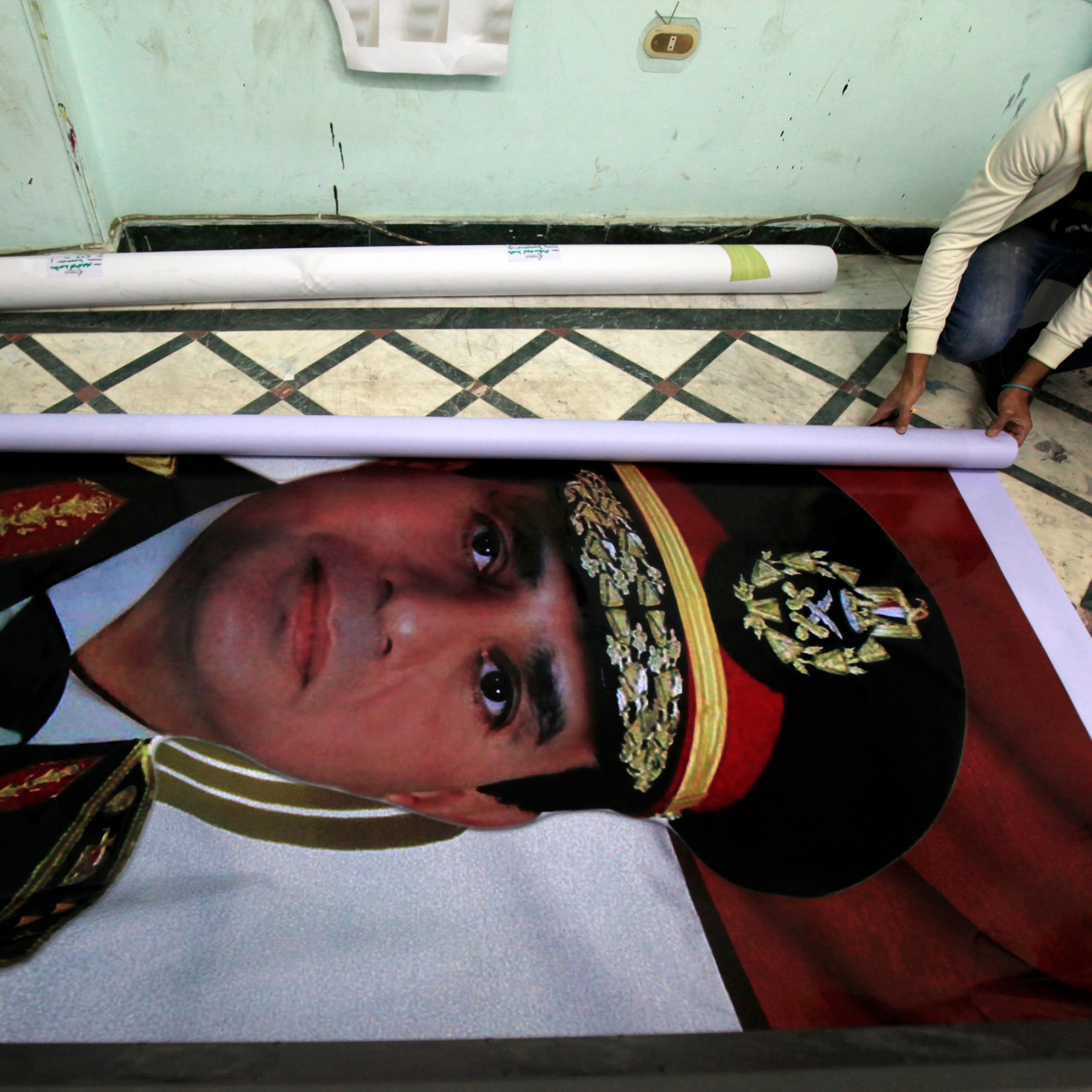 Eyes on the prize A printshop worker rolls up a poster of al-Sisi, who resigned as Egypts military chief in March in order to run for President