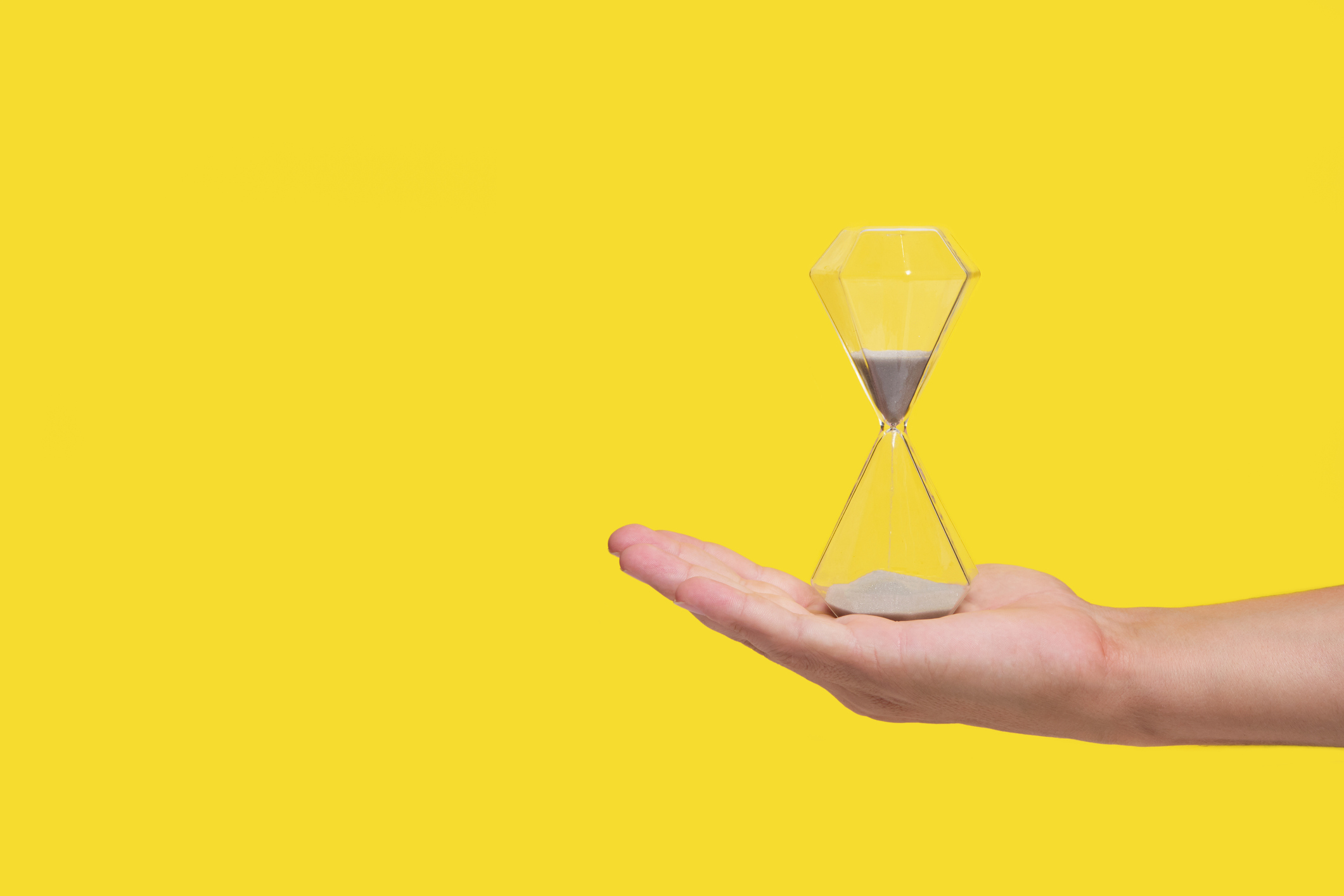 An hourglass on a man's palm