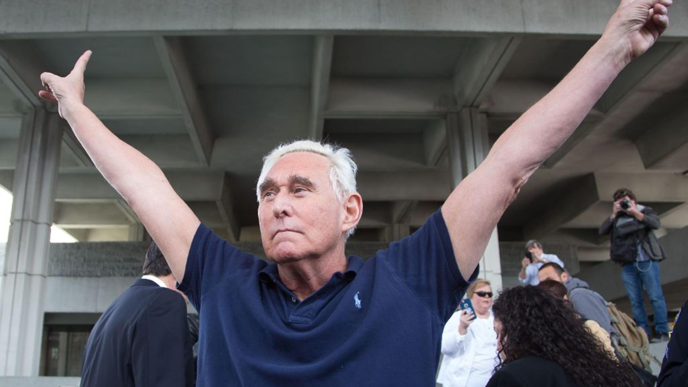 Roger Stone throws up peace signs outside court