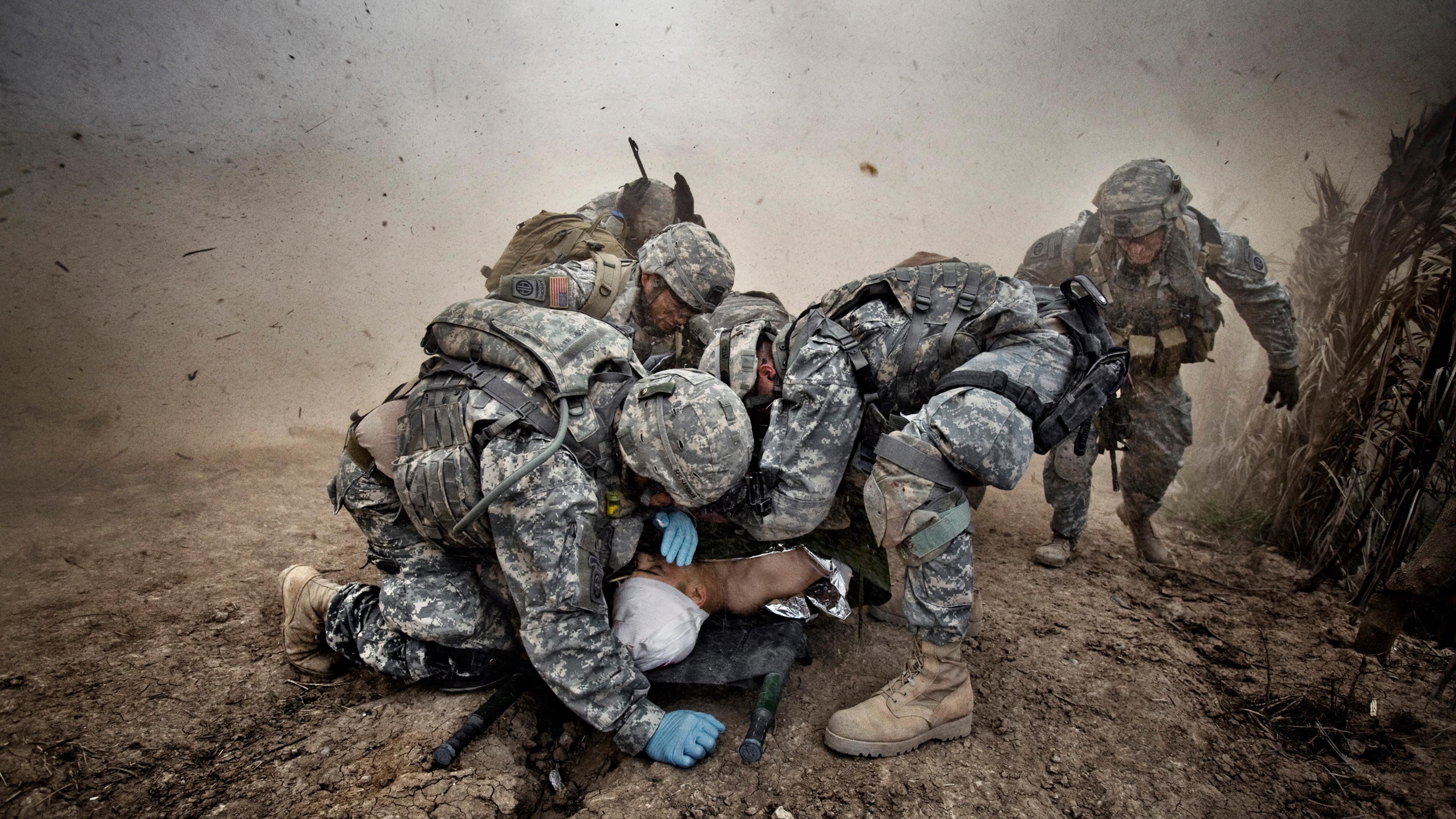 U.S. soldiers shield a wounded comrade from debris kicked up by a rescue helicopter descending on Qubah, Iraq, March 24, 2007. Fighting between U.S. forces and insurgents erupted in the village at dawn, when U.S. troops stormed the city and began house-t