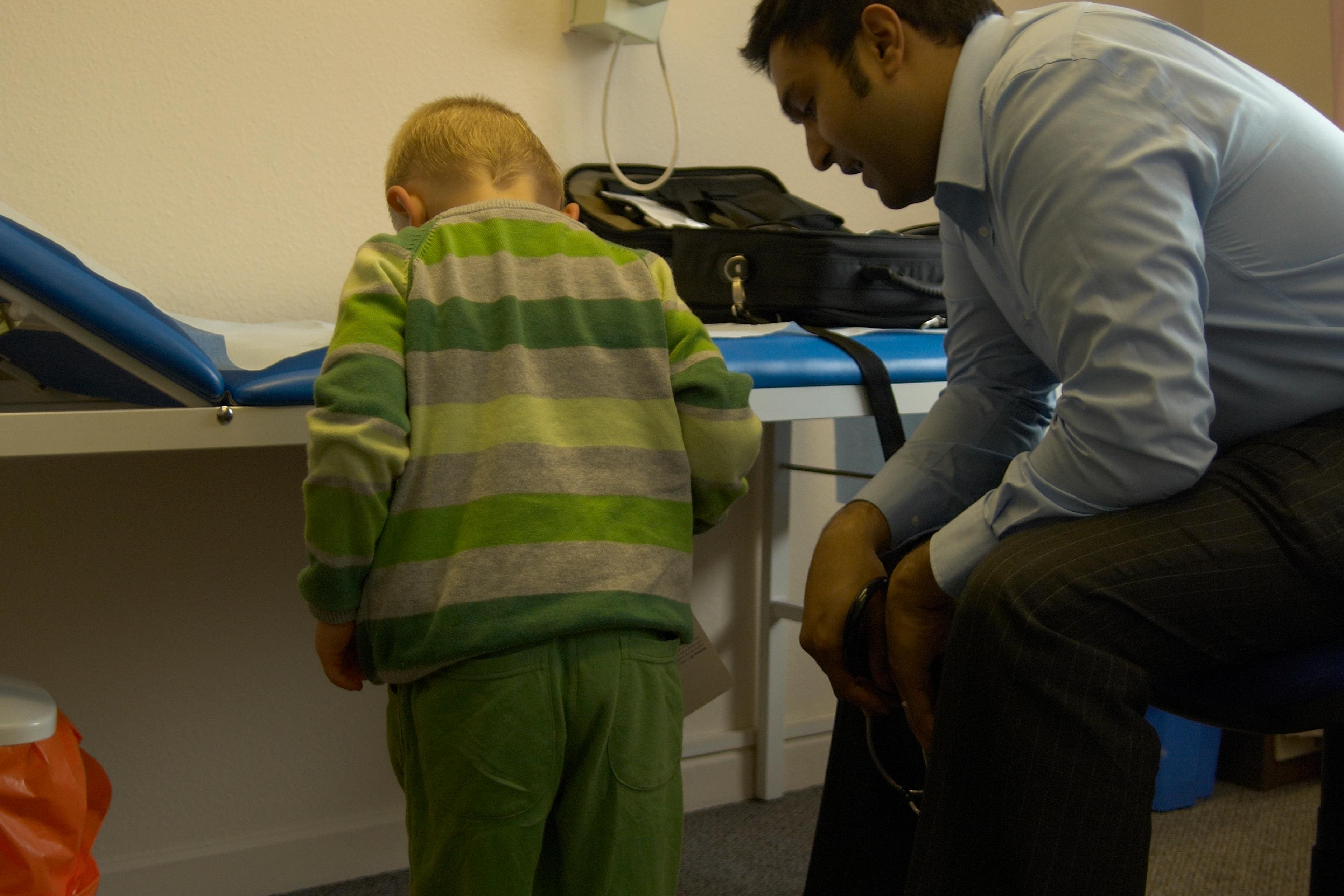 Doctor with child (2-4 years old) on weighing scales