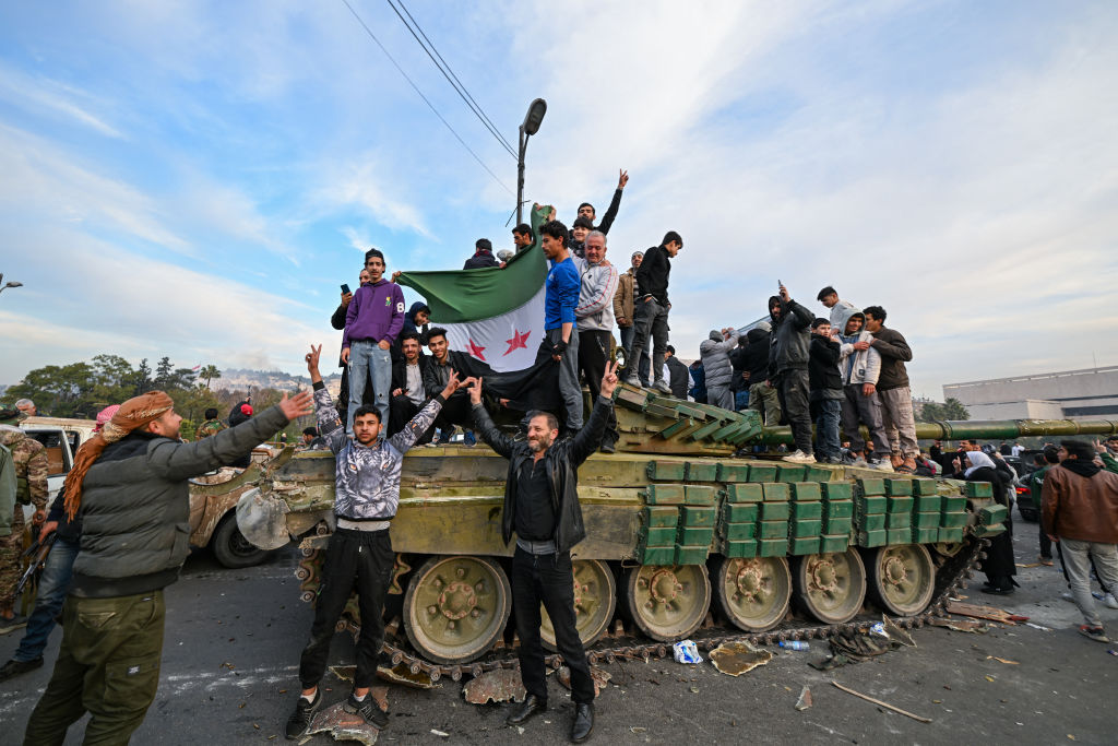 People celebrate with anti-government fighters at Umayyad Square in Damascus on Dec. 8, 2024.