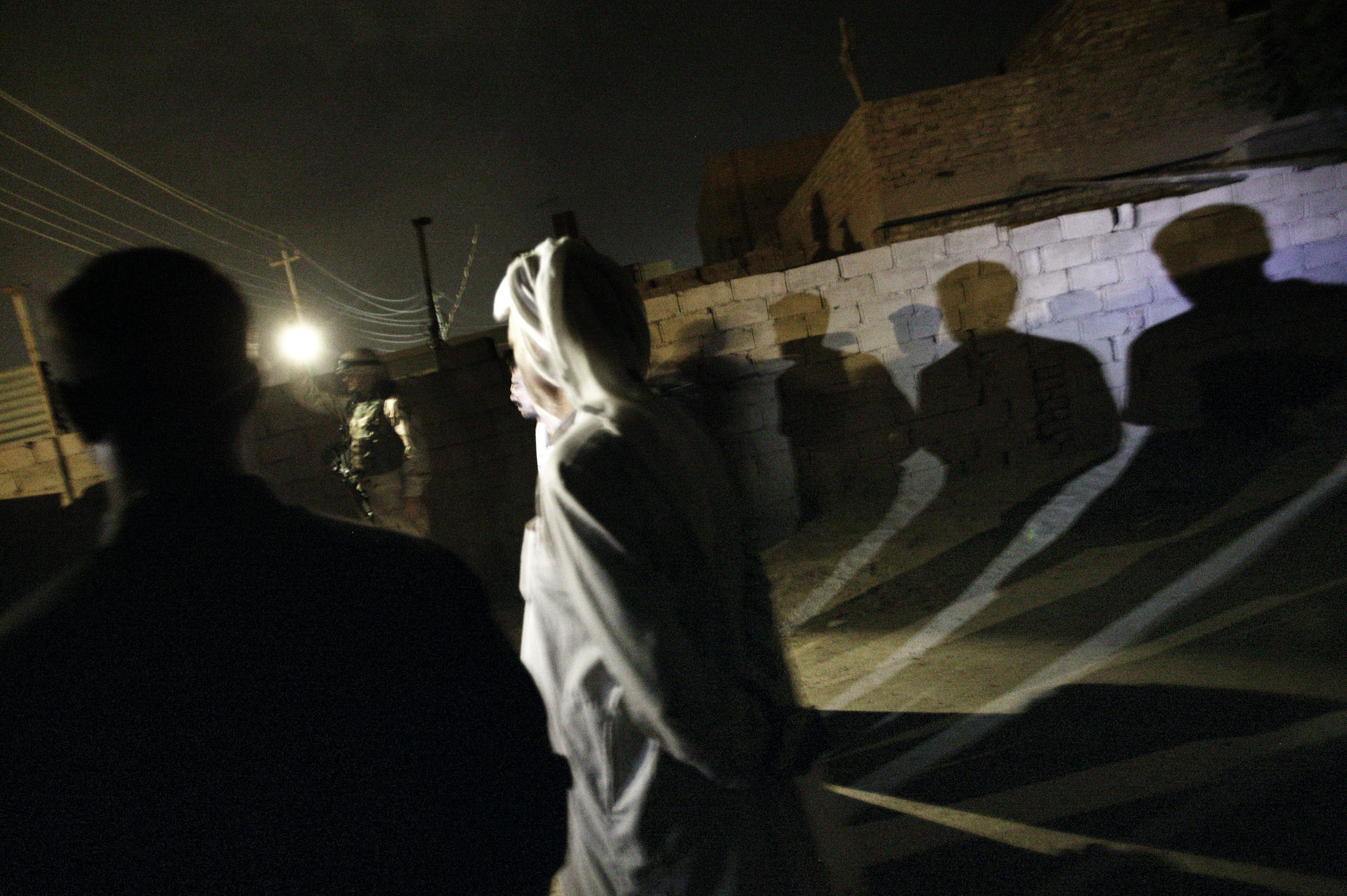 U.S. soldiers from the 2-12 Cavalry Regiment detain men during an early morning raid in the restive Abu Ghraib area of Baghdad, Oct. 20, 2004.