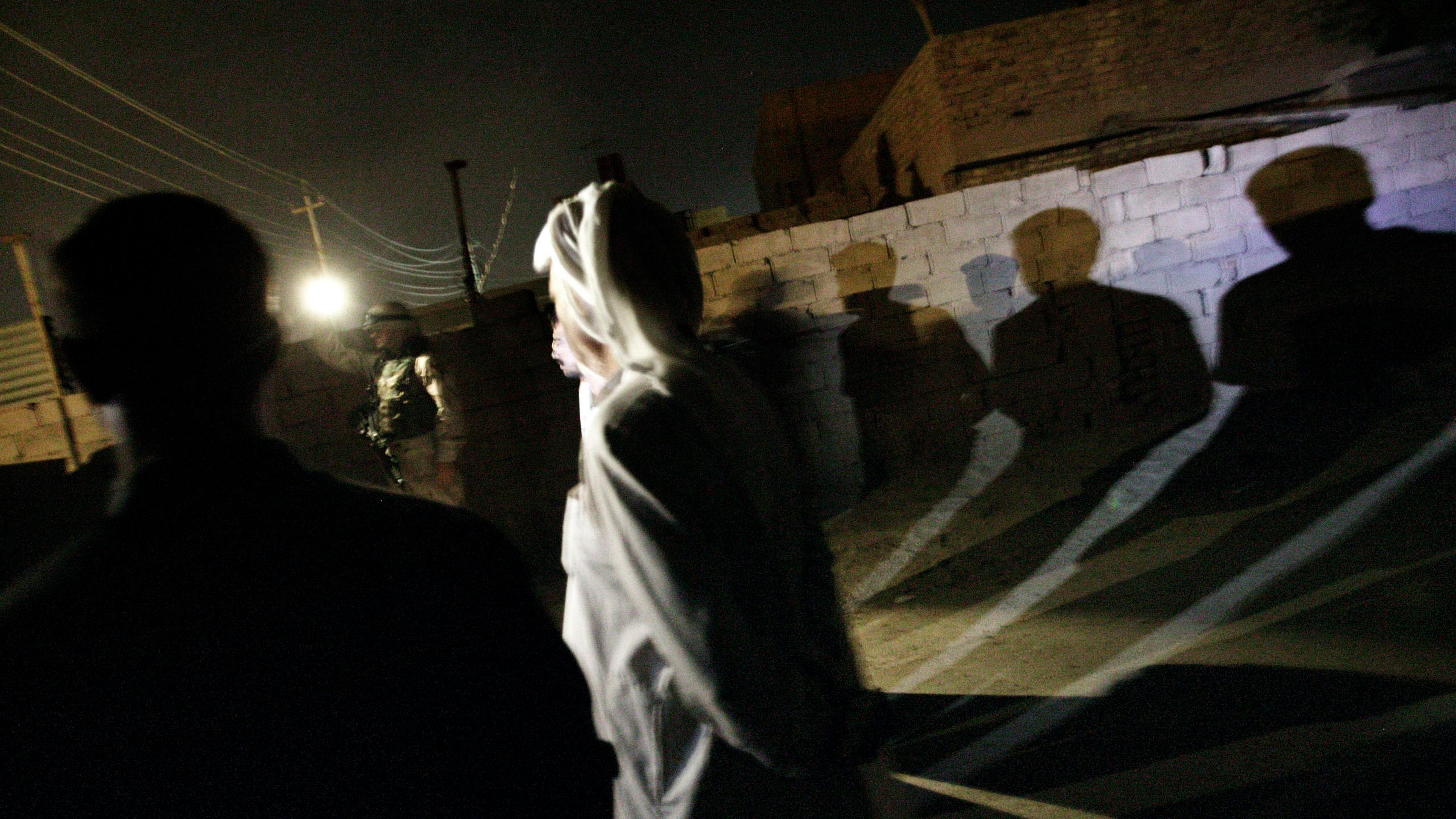 U.S. soldiers from the 2-12 Cavalry Regiment detain men during an early morning raid in the restive Abu Ghraib area of Baghdad, Oct. 20, 2004.
