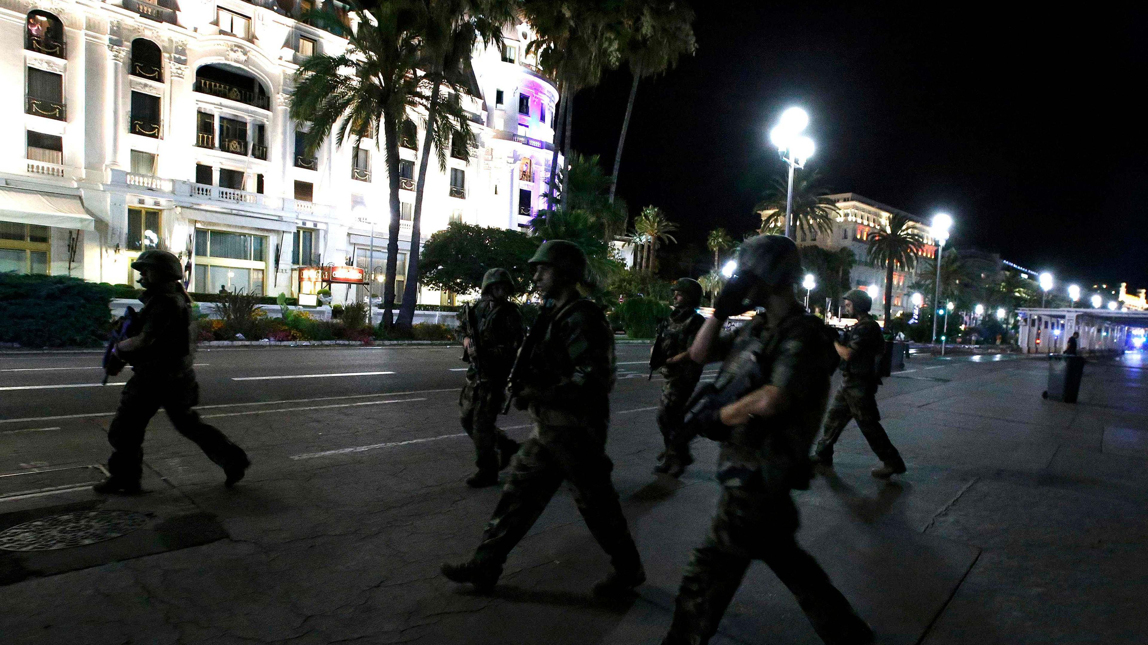 French soldiers advance on the street after at least 70 people were killed in Nice, France, when a truck ran into a crowd celebrating the Bastille Day national holiday on July 14, 2016.