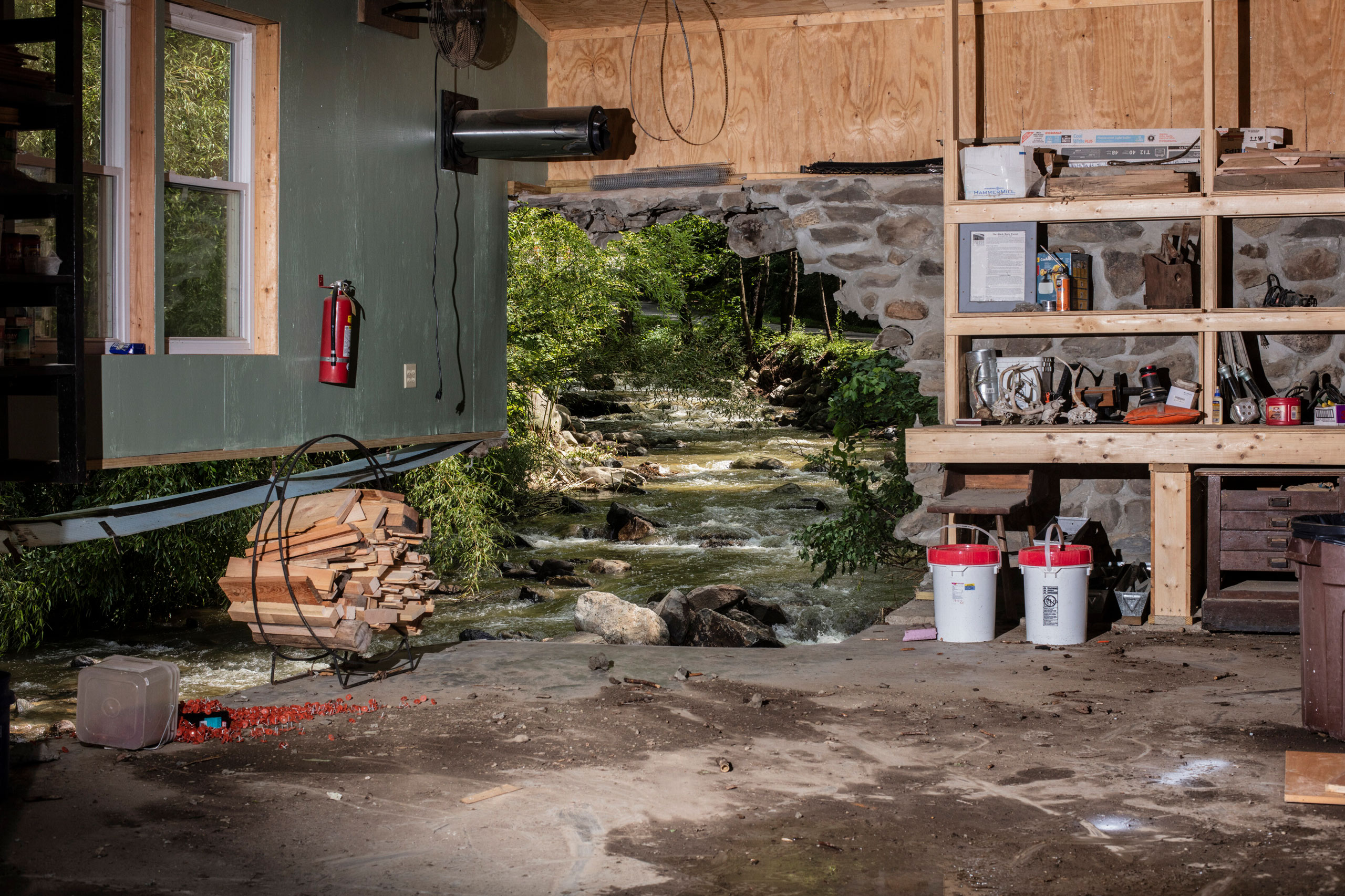 A workshop wall opened to the brook beyond after flash flooding