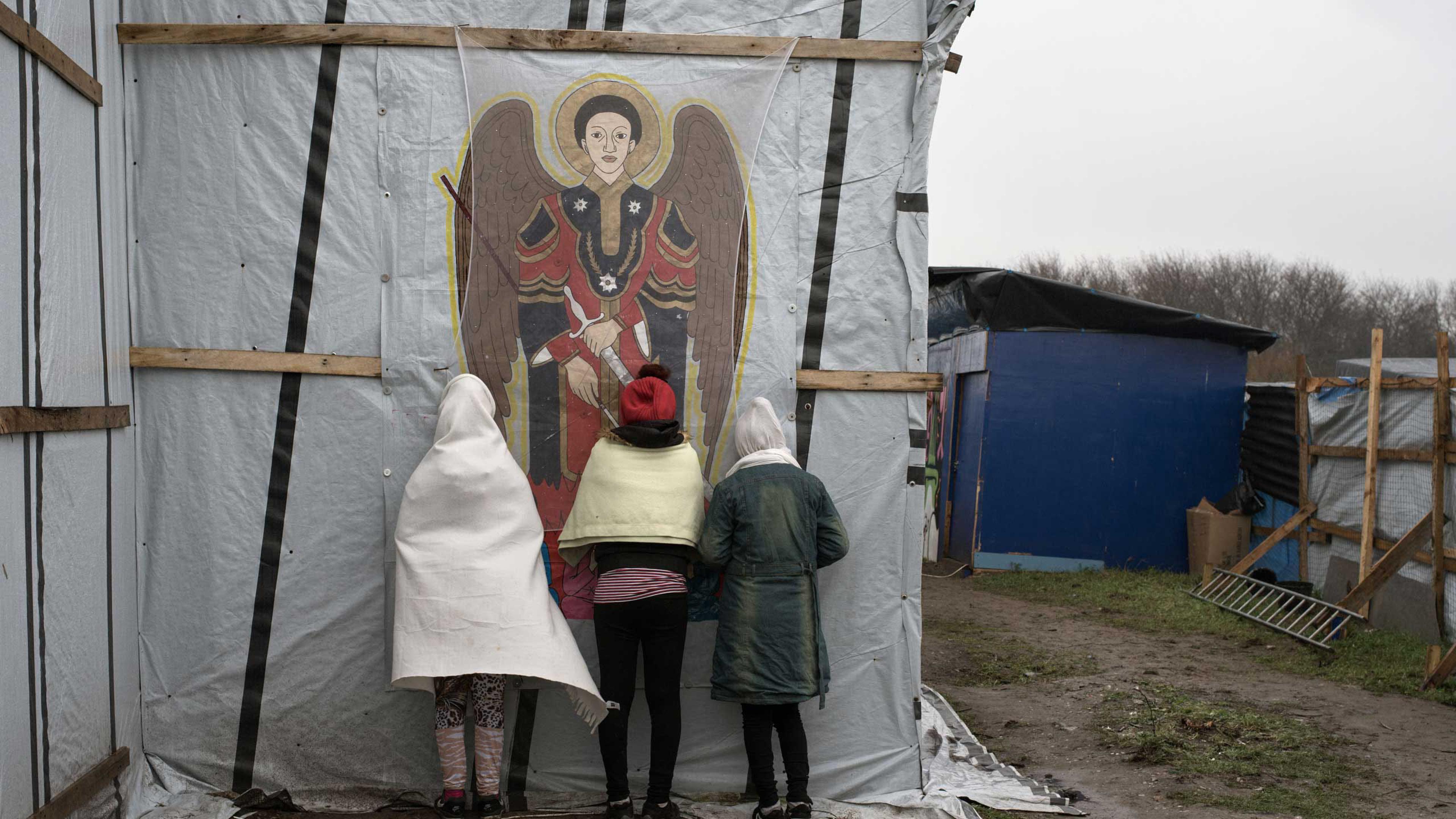 Orthodox Christians pray outside the makeshift church known as St. Michael's Calais for the Ethiopian and Eritrean community in the "jungle" of Calais, France, Nov. 24, 2015.