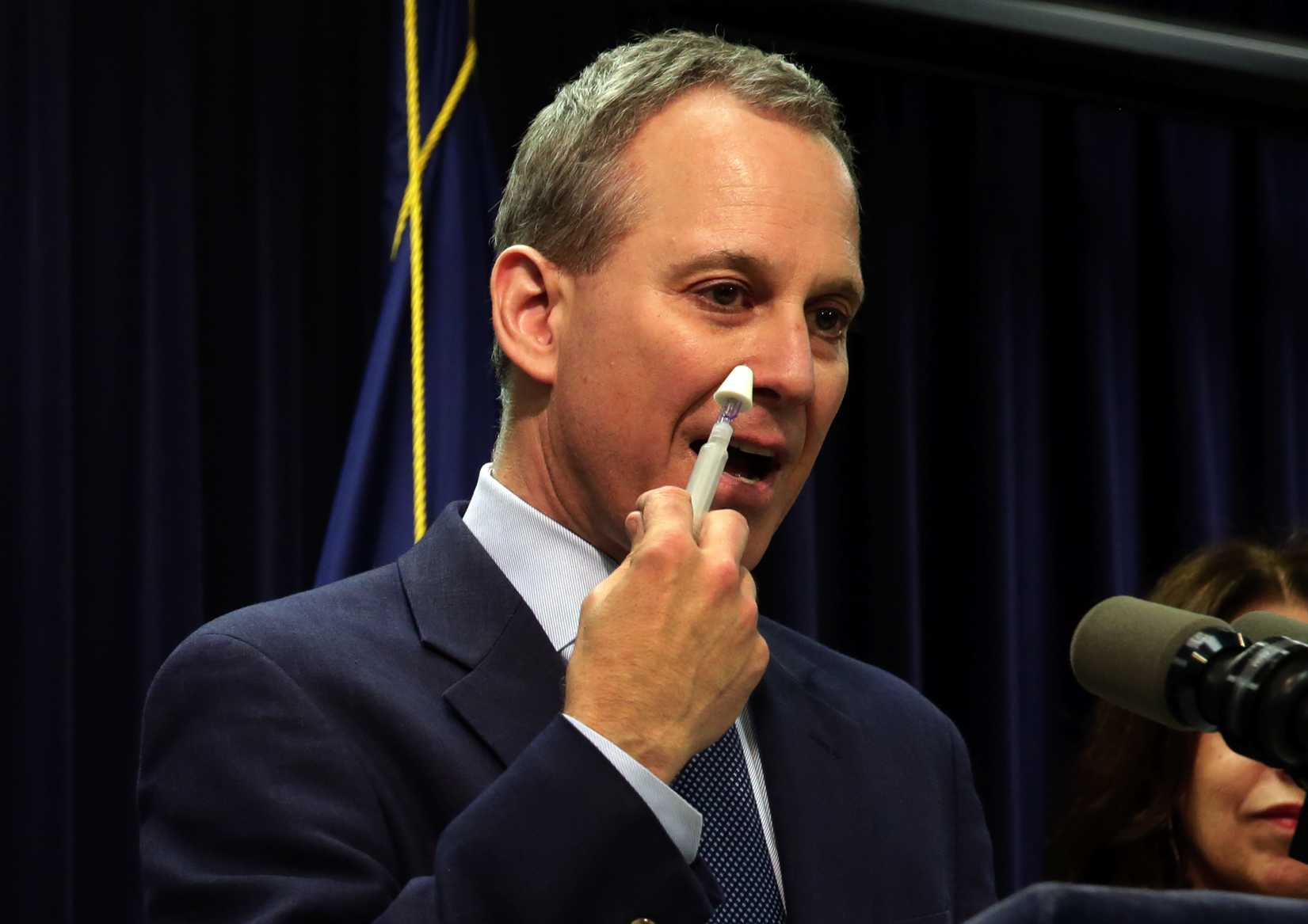 New York State Attorney General Eric Schneiderman demonstrates an inhaler of naloxone, a drug to be included in an overdose-prevention rescue kit, during a news conference in New York City on May 27, 2014