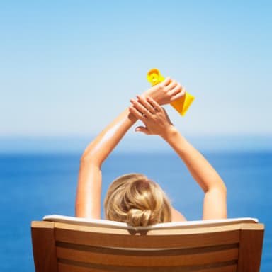 woman-sitting-sun-beach-cream