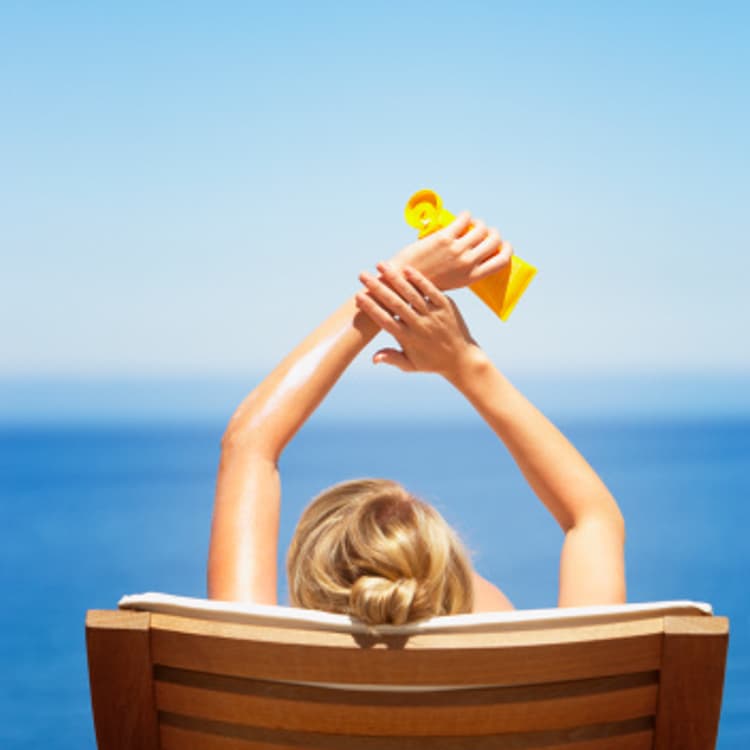 woman-sitting-sun-beach-cream