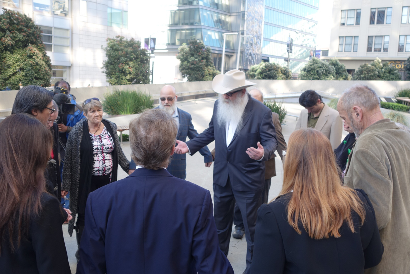 Bryan Davies, owner of medical marijuana dispensary Canna Care, leads supporters in prayer before facing the Internal Revenue Service in tax court on Feb. 24, 2014.