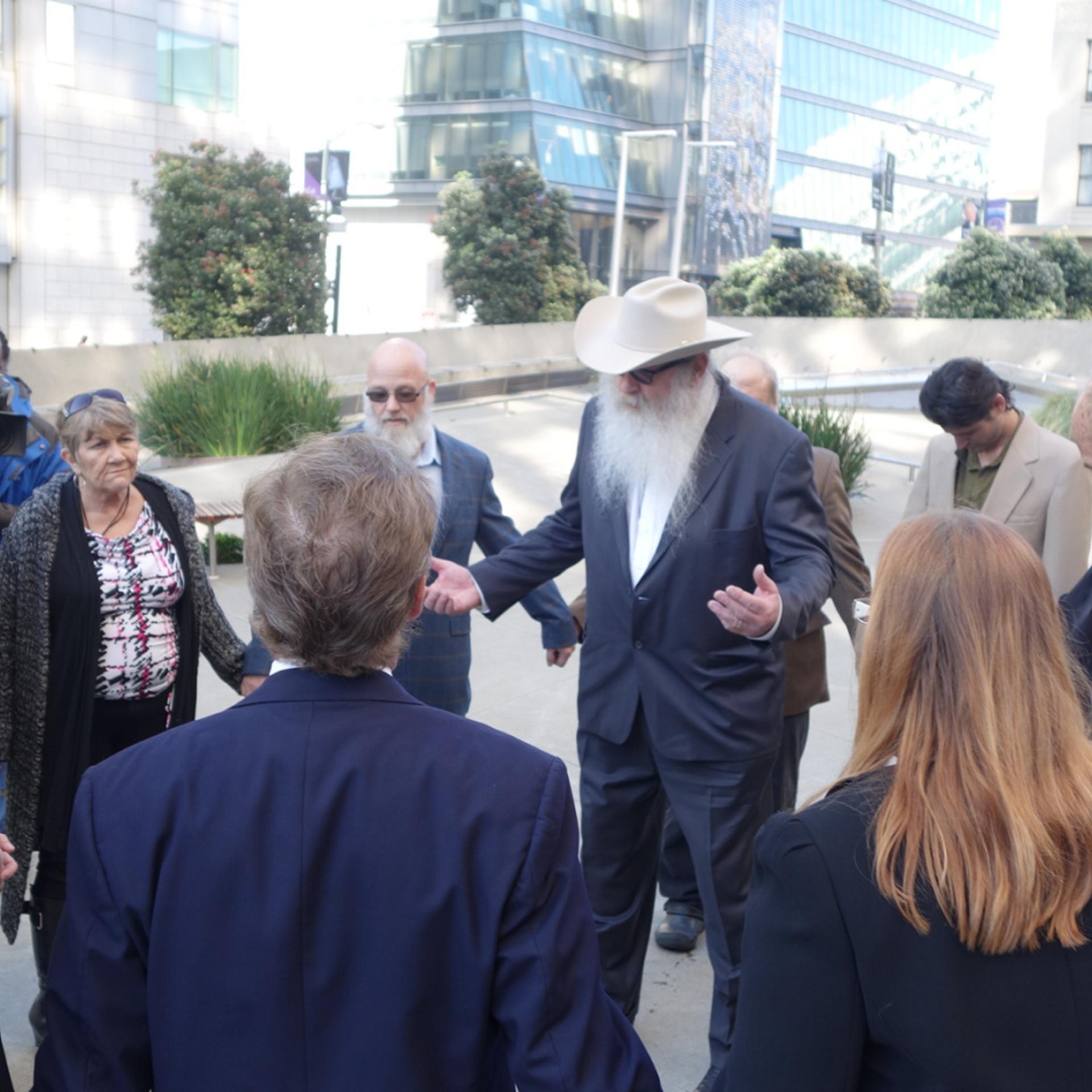 Bryan Davies, owner of medical marijuana dispensary Canna Care, leads supporters in prayer before facing the Internal Revenue Service in tax court on Feb. 24, 2014.