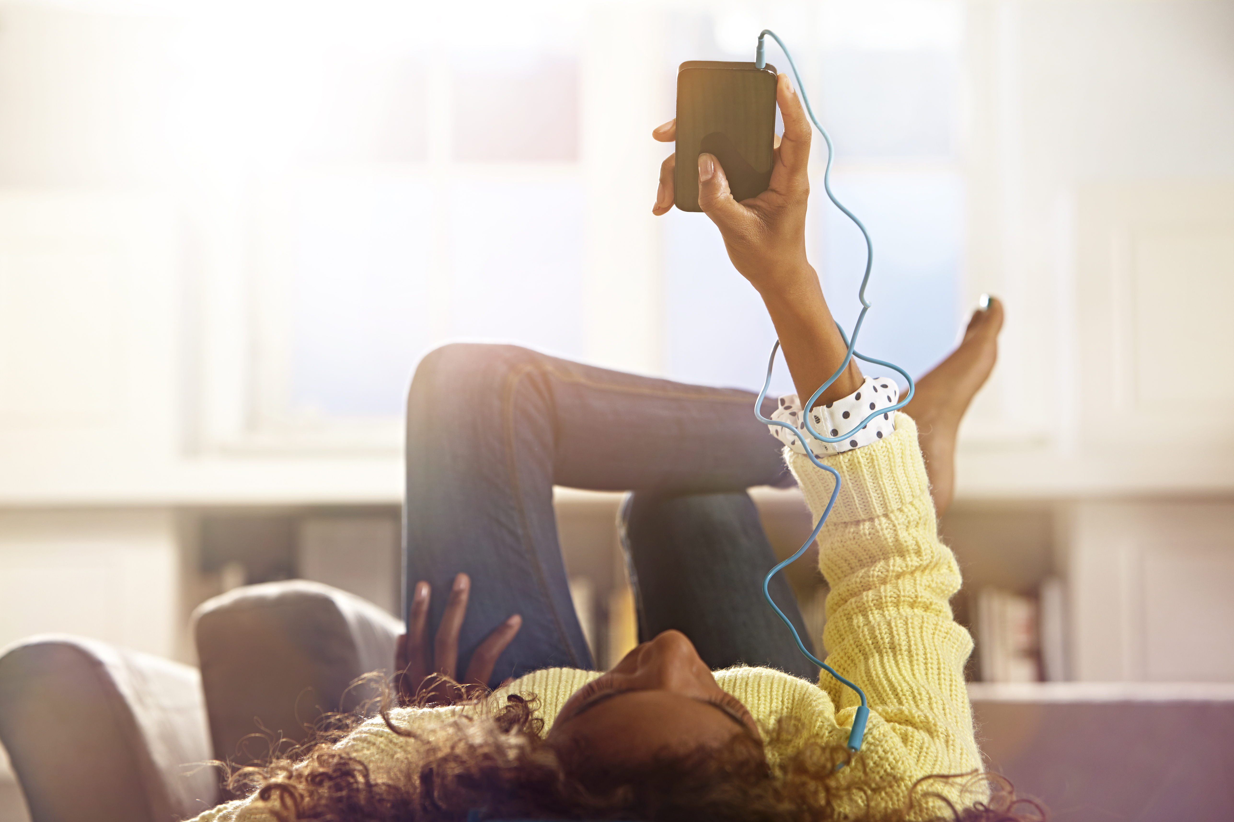 Woman relaxing at home listening to her phone.