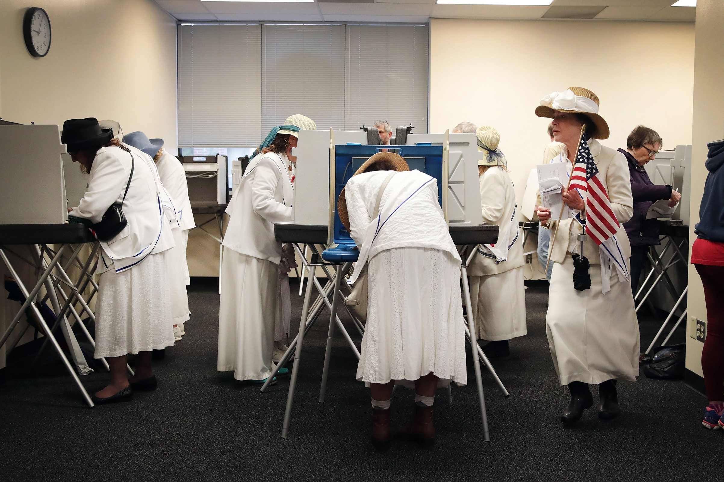Women dressed as suffragettes cast ballots for the midterm elections at the Polk County Election Office on Oct. 8, 2018 in Des Moines.