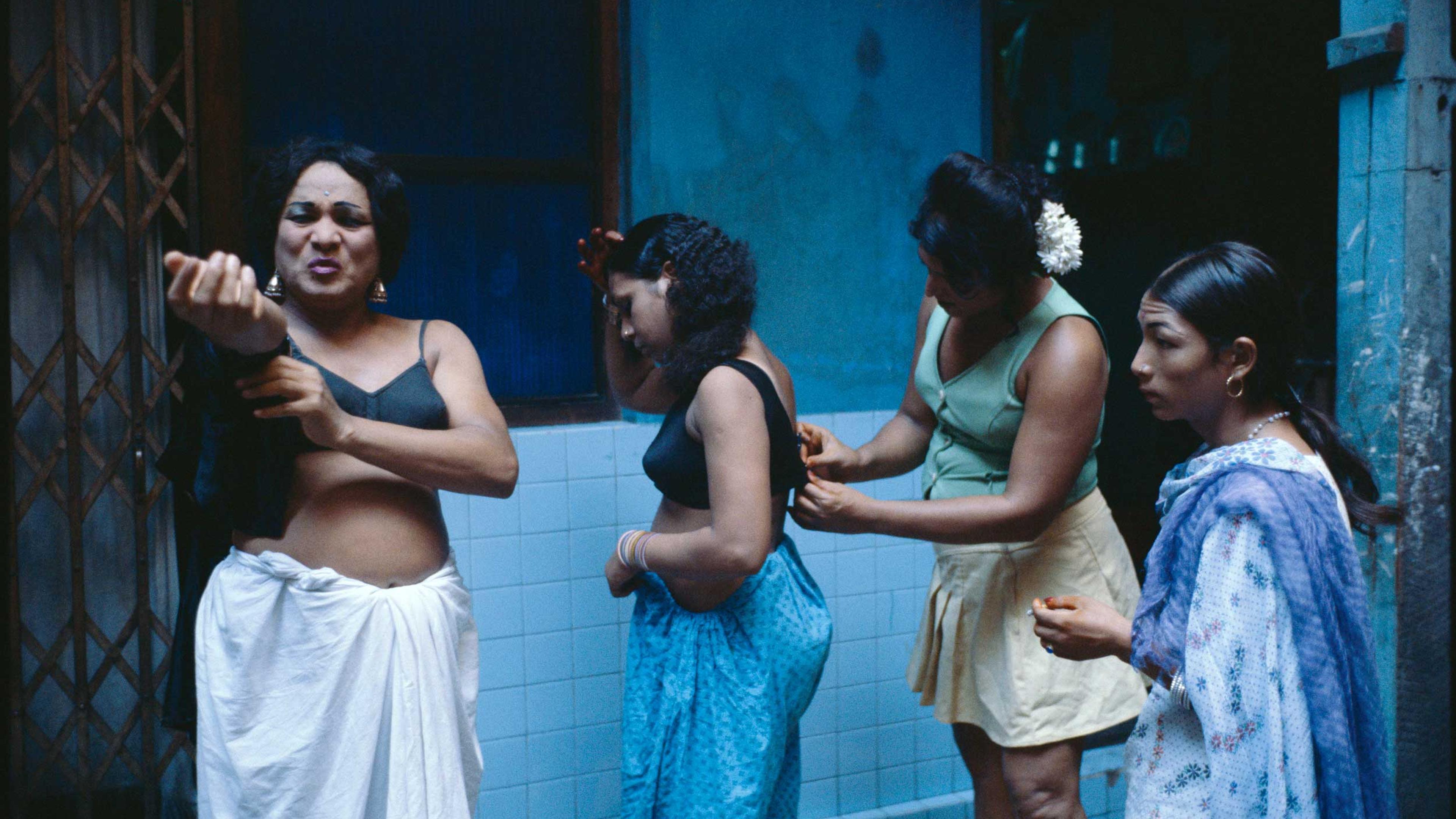Transvestites getting dressed in a courtyard.