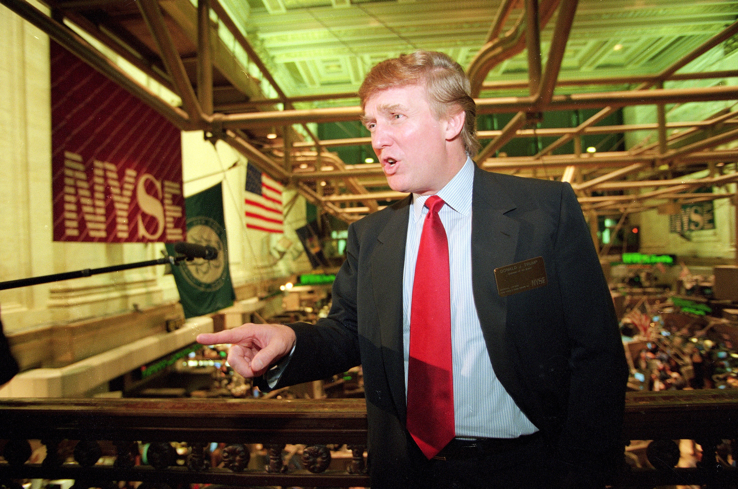 File-This June 7, 1995, file photo shows real estate magnate Donald Trump posing for photos above the floor of the New York Stock Exchange after taking his flagship Trump Plaza Casino public in New York City. Trump's business losses in 1995 were so large