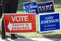 Signs are seen on a lawn near a US polling place in Arlington, Virginia, November 8, 2016.