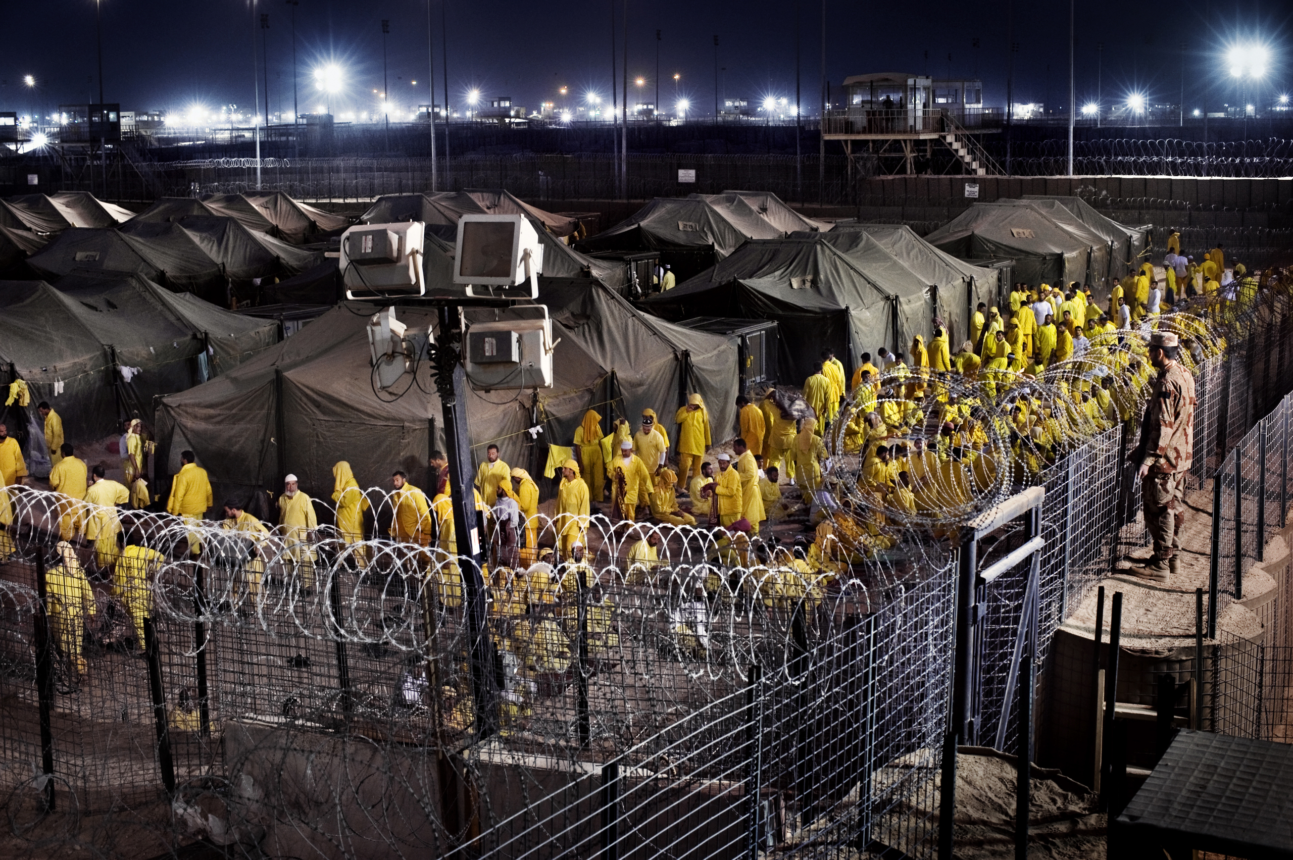Detainees walk after prayer at Camp Bucca, a U.S. military detention center, March 16, 2009. At its peak, the prison located 340 miles southeast of Baghdad held 26,000 detainees.
