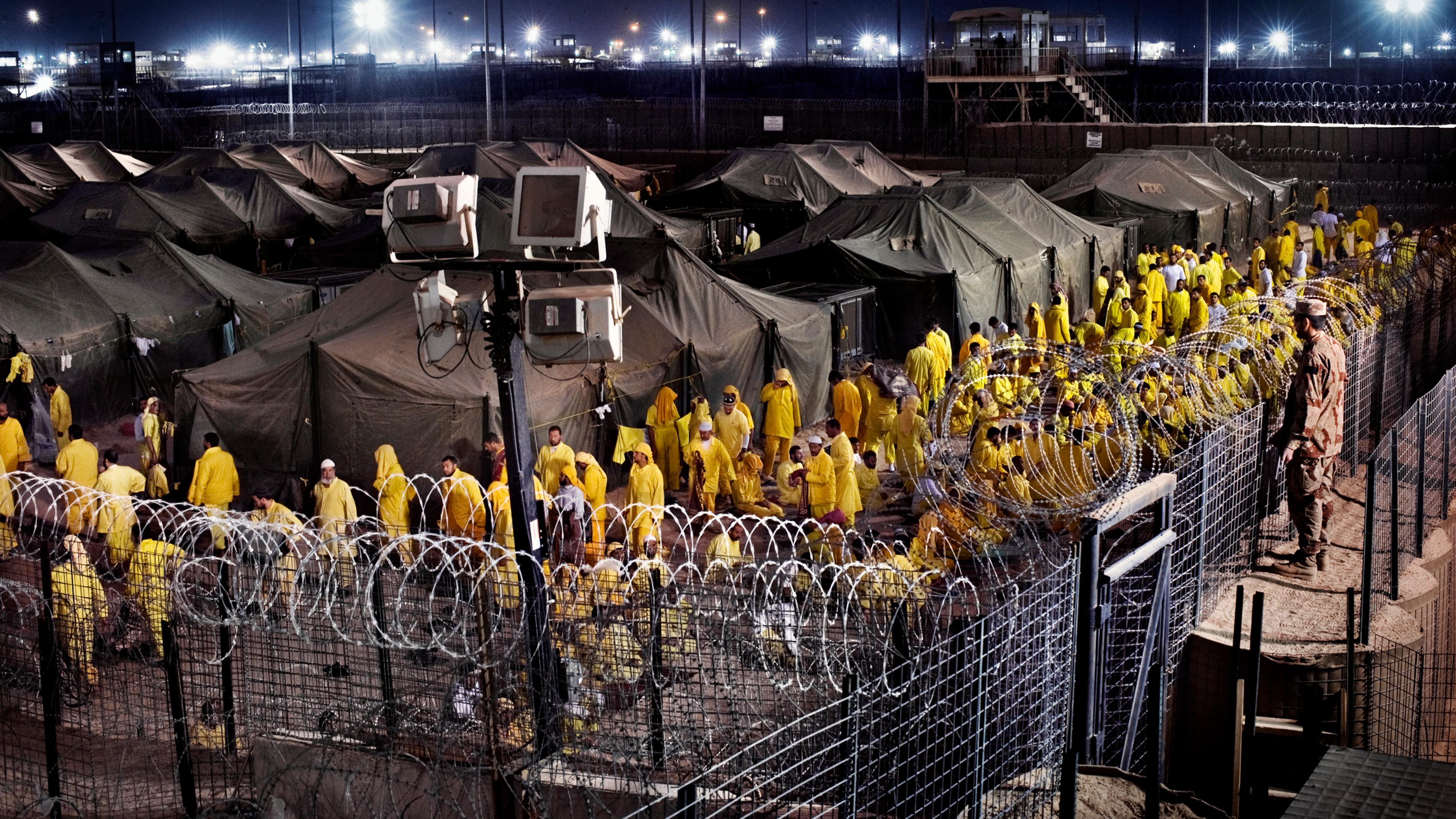 Detainees walk after prayer at Camp Bucca, a U.S. military detention center, March 16, 2009. At its peak, the prison located 340 miles southeast of Baghdad held 26,000 detainees.