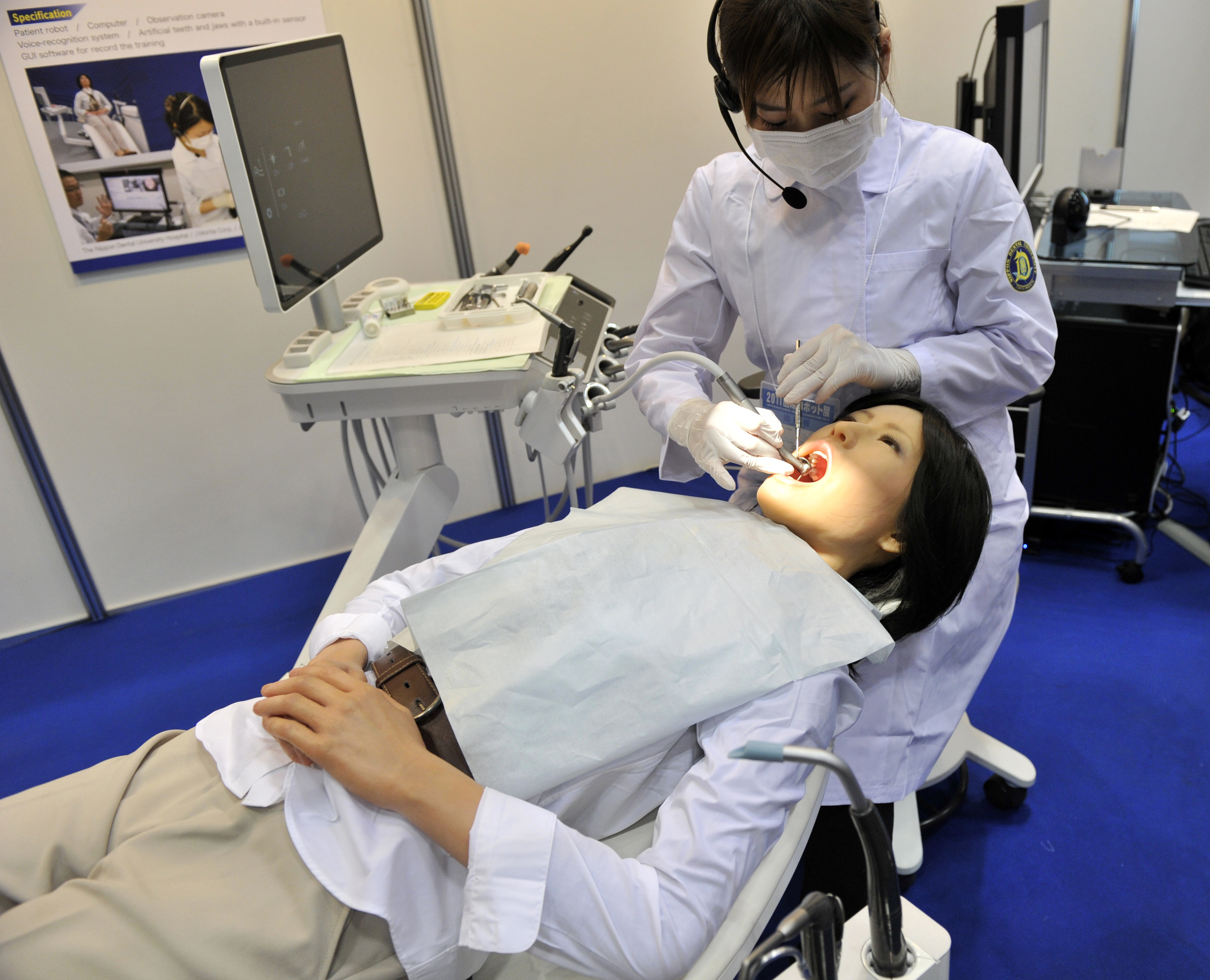 A Nippon Dental University Hospital staff member demonstrates a humanoid robot dental therapy simulator named "Simroid" at the International Robot Exhibition in Tokyo on November 9, 2011.