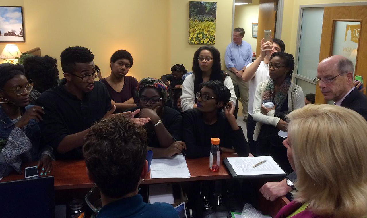 Student activists, including Bilphena Yahwon (left) and John Gillespie (second from left) talk with administrators, including then-Interim President Timothy Chandler (right), at a student-led sit-in of the president's office at Towson University the nigh