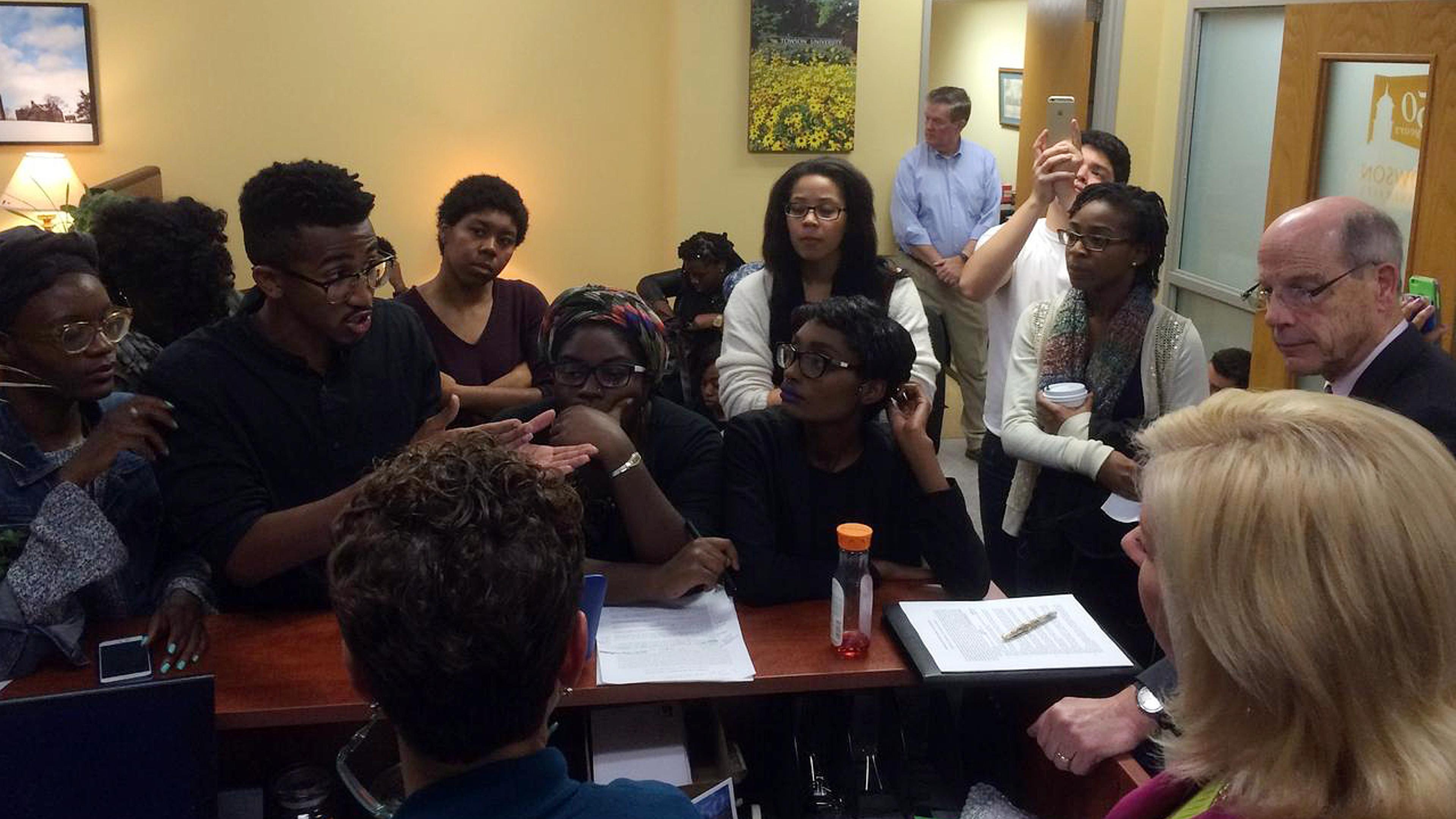 Student activists, including Bilphena Yahwon (left) and John Gillespie (second from left) talk with administrators, including then-Interim President Timothy Chandler (right), at a student-led sit-in of the president's office at Towson University the nigh