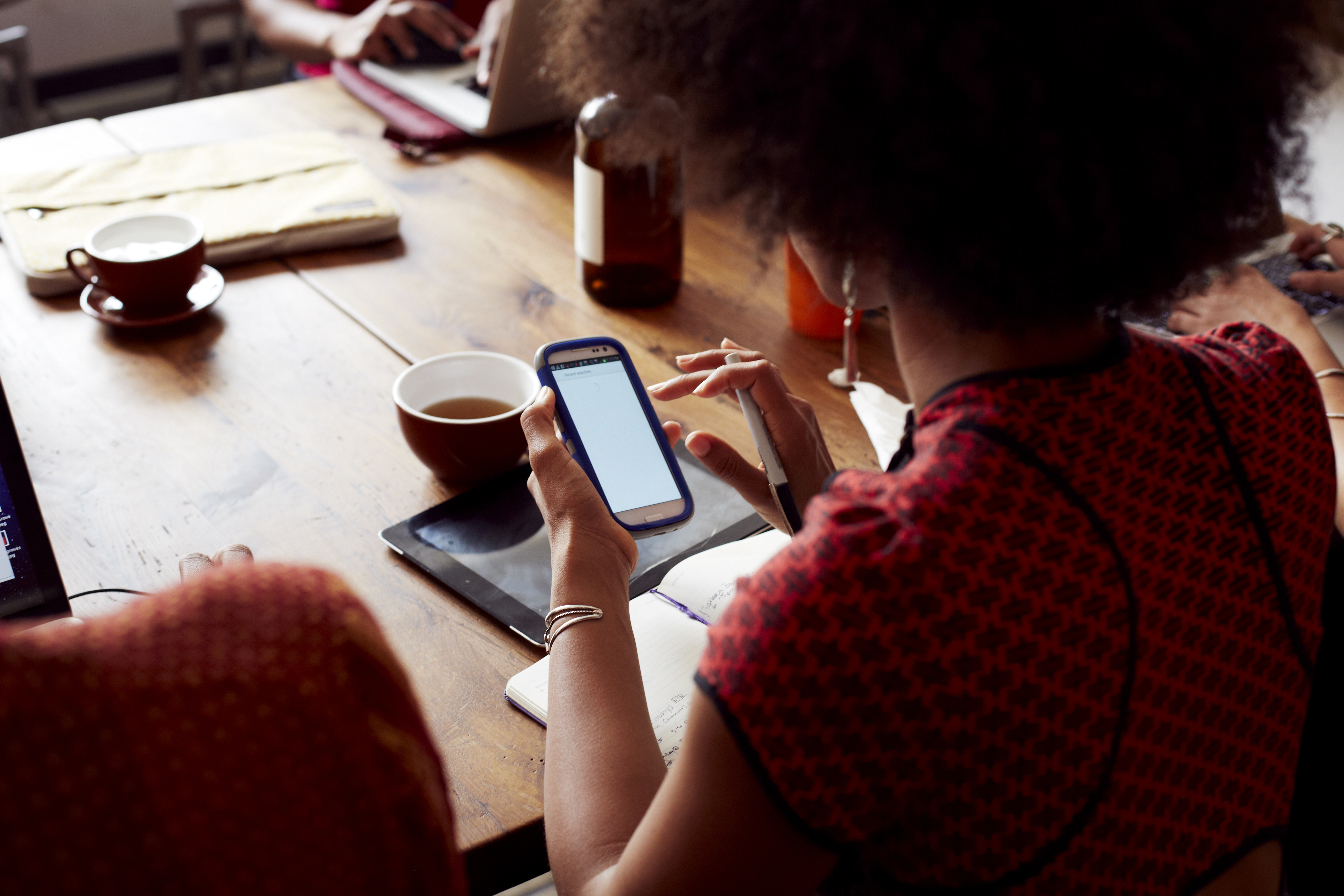 Businesswoman using cell phone in cafe
