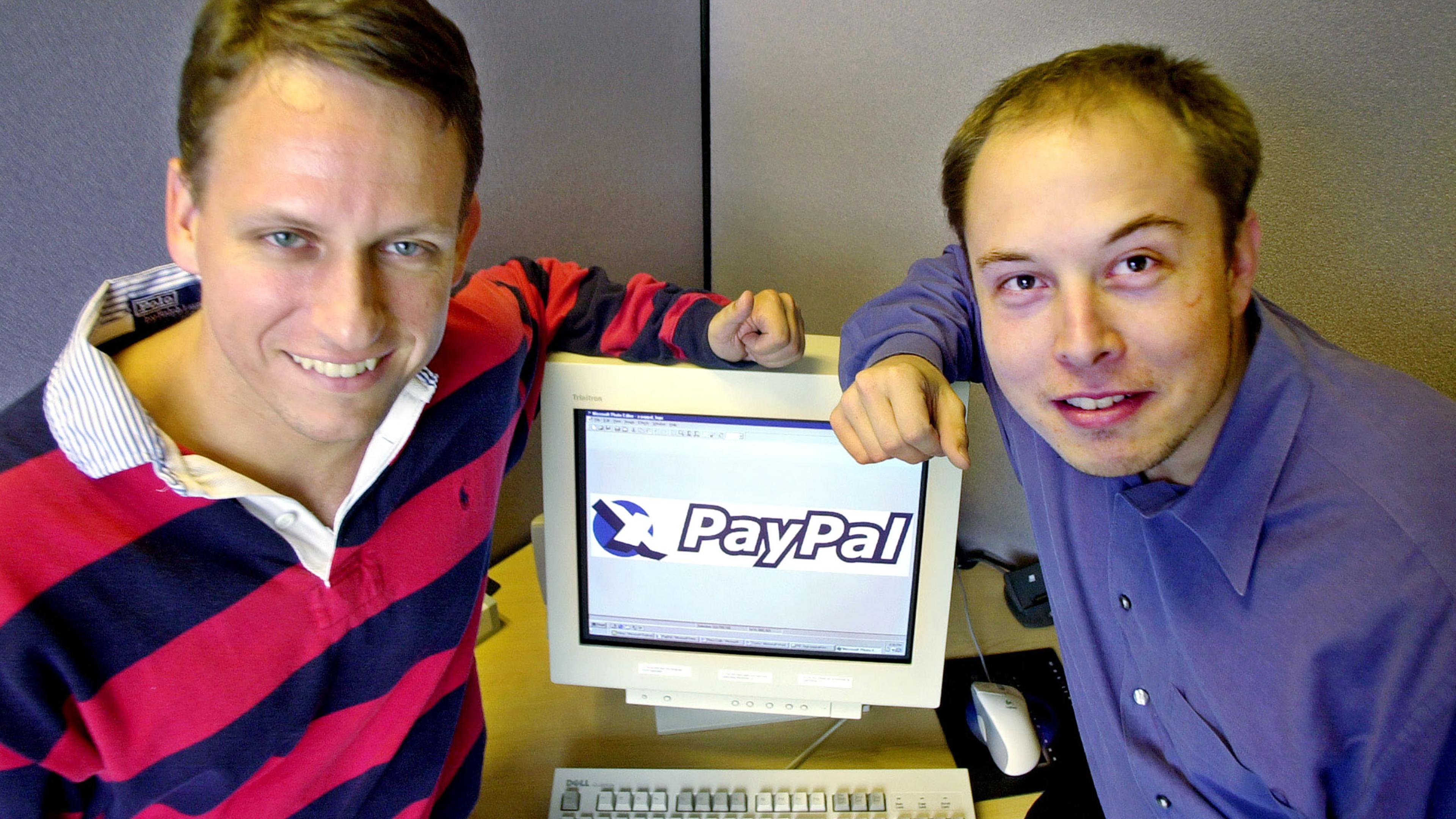 PayPal Chief Executive Officer Peter Thiel, left, and founder Elon Musk, right, pose with the PayPal logo at corporate headquarters in Palo Alto, Calif. on Oct. 20, 2000.