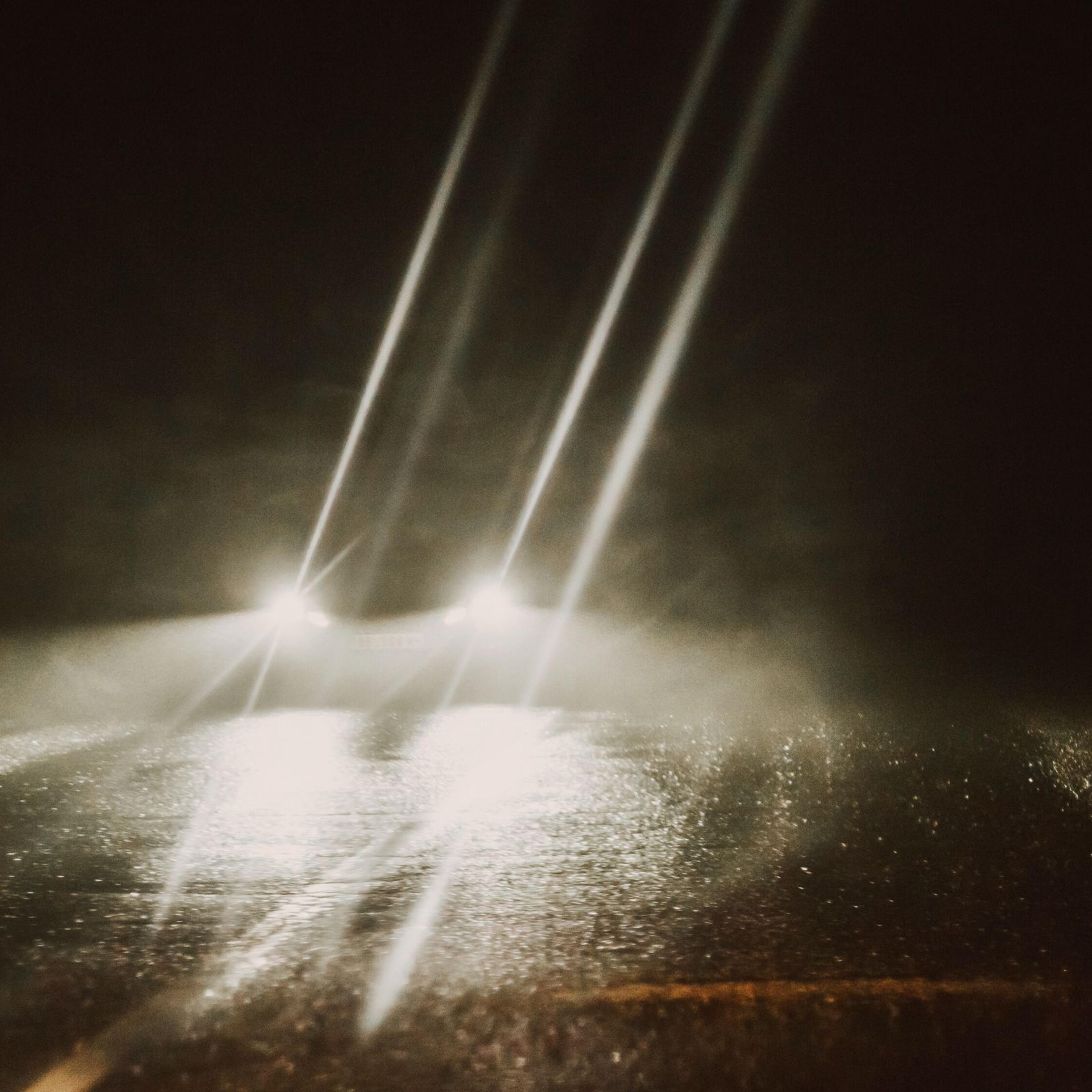 A car at night with headlights on.