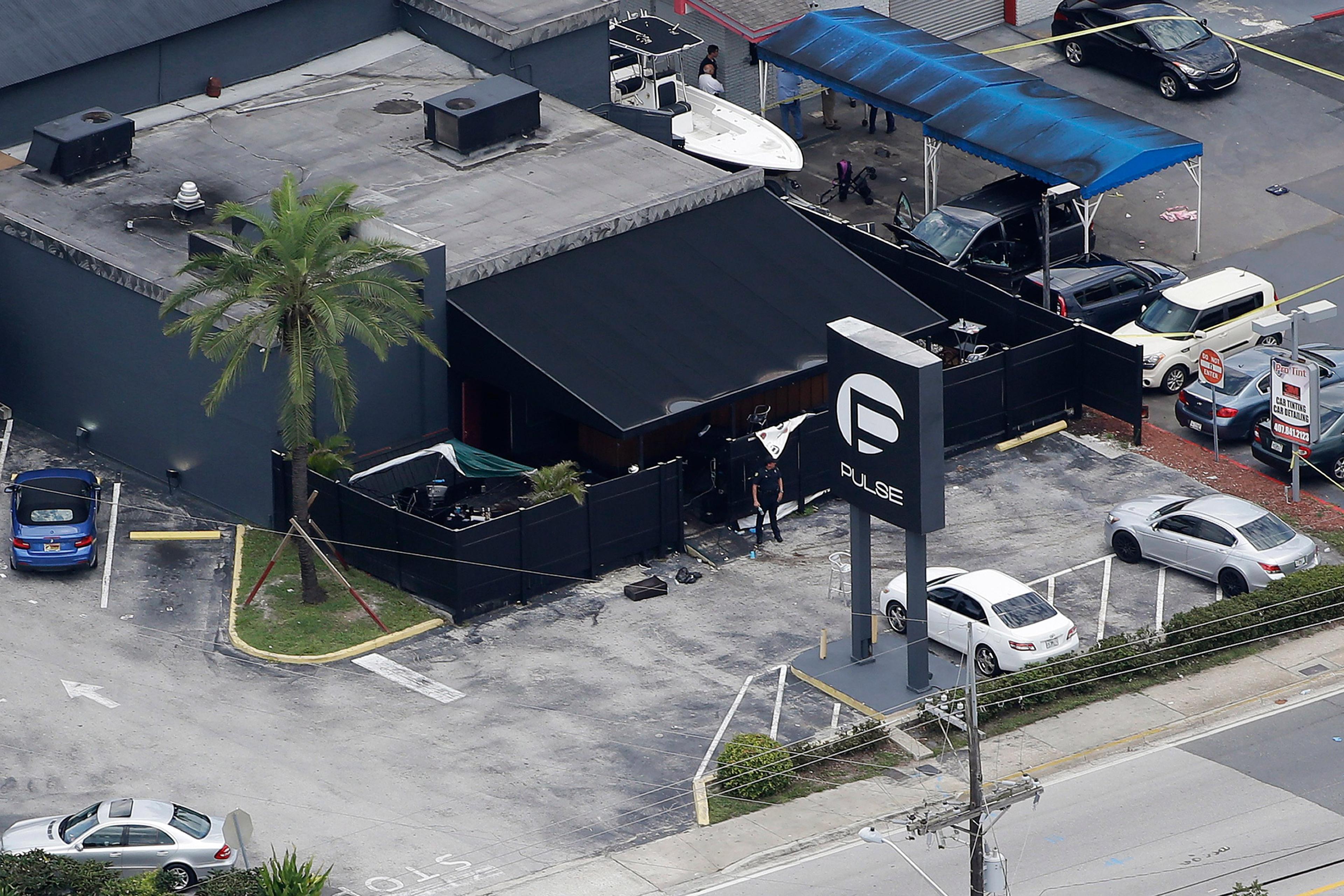 Law enforcement officials work at the Pulse Orlando nightclub following a fatal shooting Sunday, June 12, 2016, in Orlando, Fla. . (AP Photo/Chris O'Meara)
