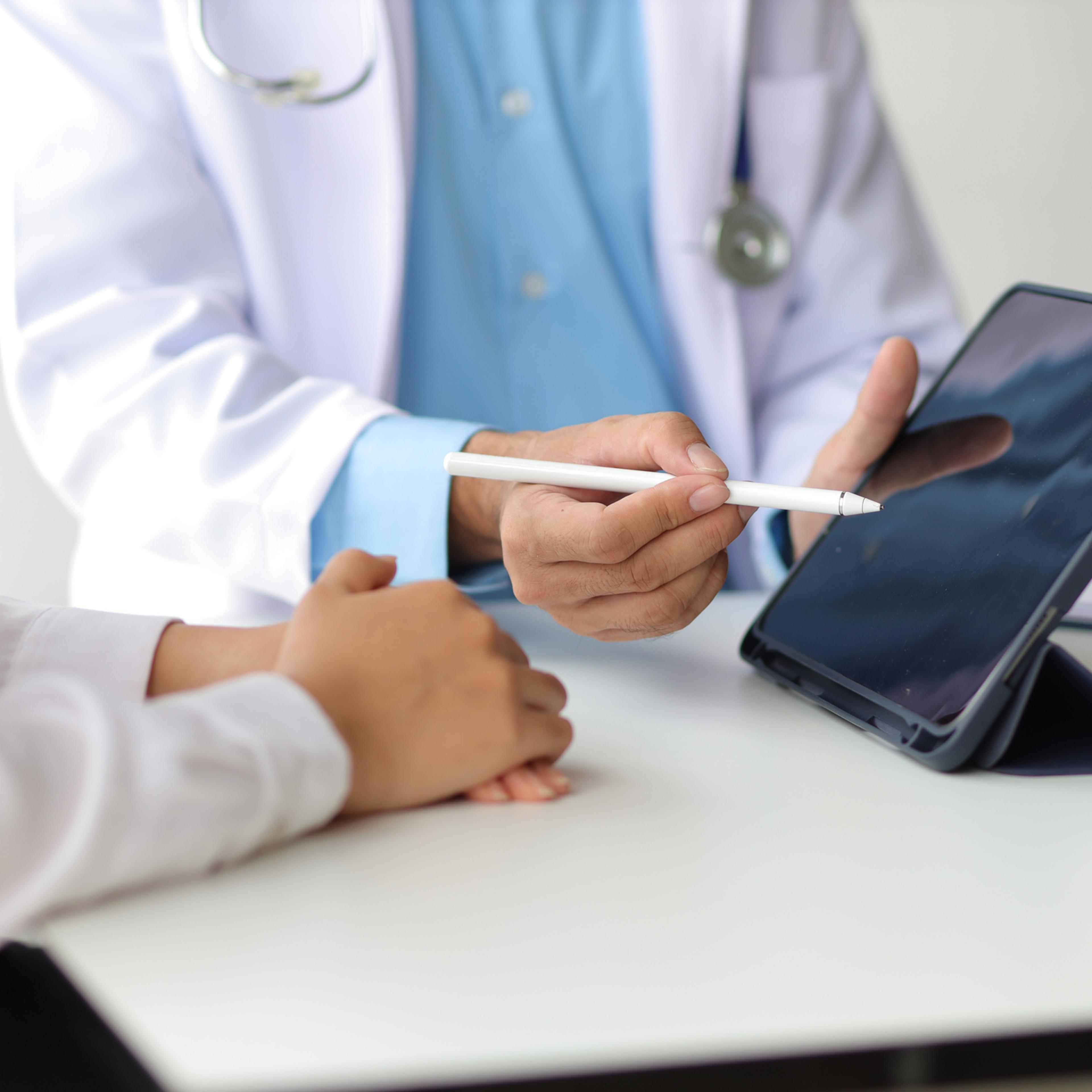 Doctor showing a patient some information on a digital tablet. Health examination and treatment of disease.