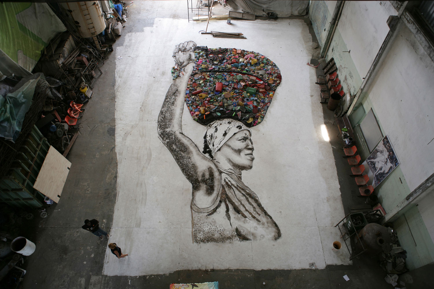 The portrait of Irma is created on the floor of the studio by Muniz and the workers of Jardim Gramacho. Once complete, the final portrait will be photographed from above by Muniz