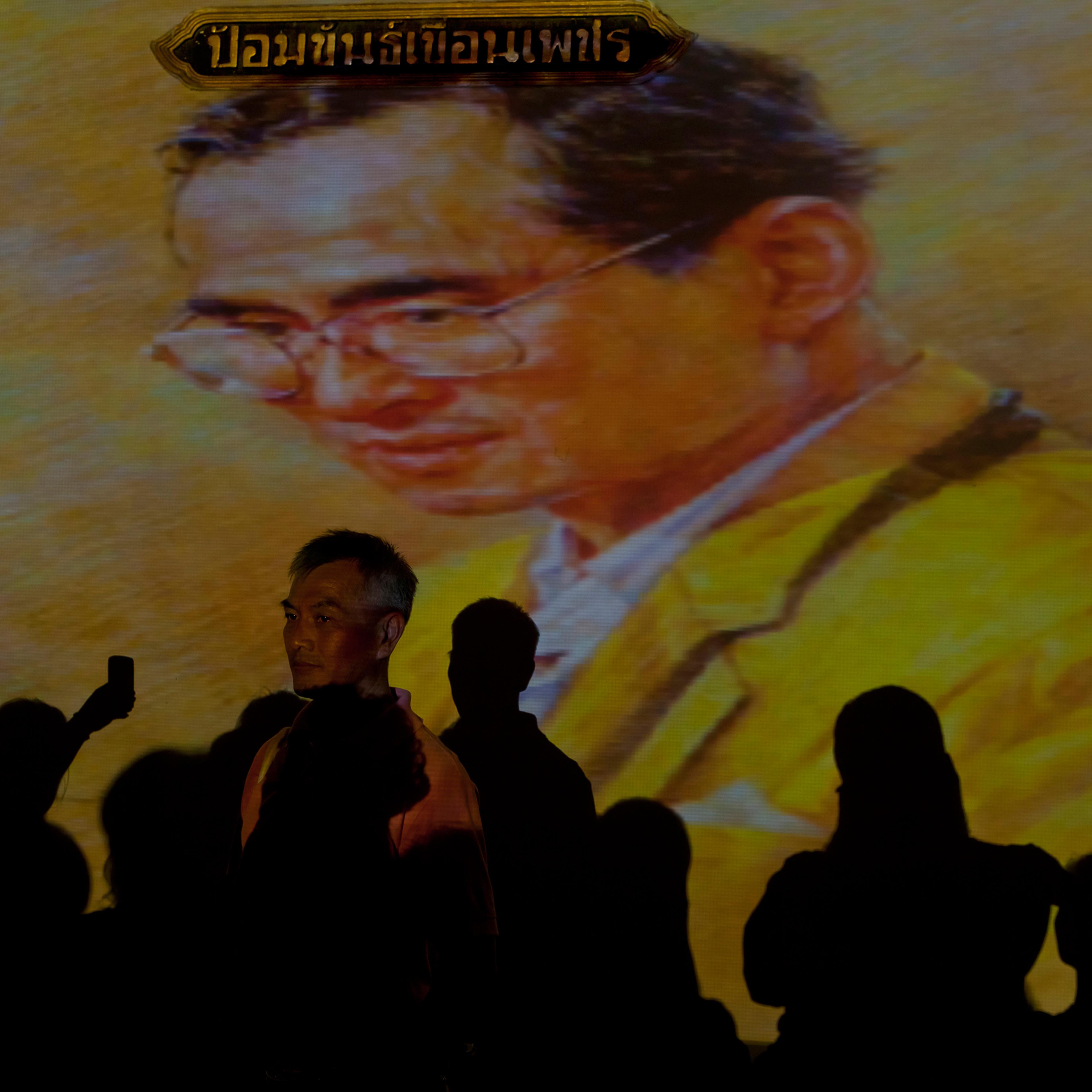 People in front of an image of King Bhumibol Adulyadej of Thailand during a celebration of his 84th birthday, Bangkok, Thailand, Dec. 5, 2011.