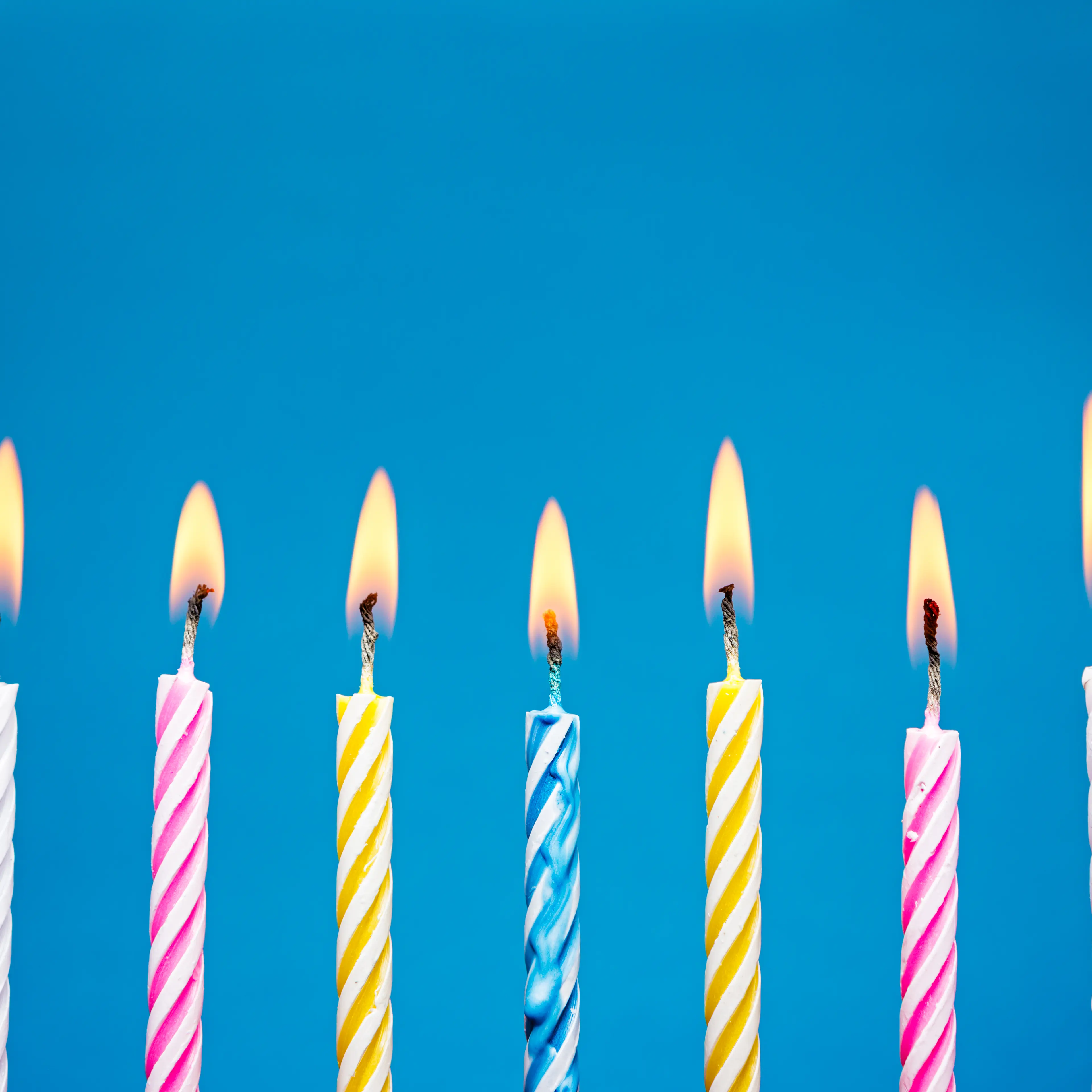Flaming Birthday Candles on blue background TIME health stock