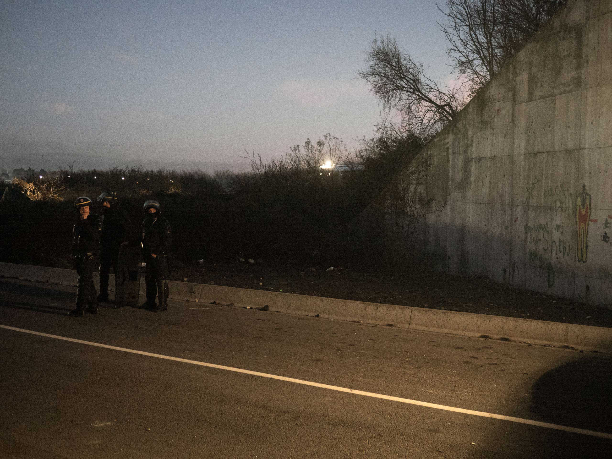 Anti-riot police (CRS) during a tense face-off with a group of migrants. As it has become harder for migrants to cross to the United Kingdom, confrontations with police have become more frequent, Nov. 25, 2015, Calais, France.