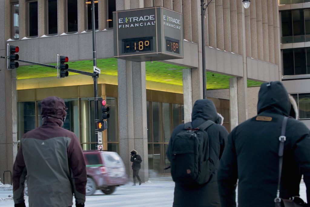 Commuters pass a thermometer during polar vortex in Chicago