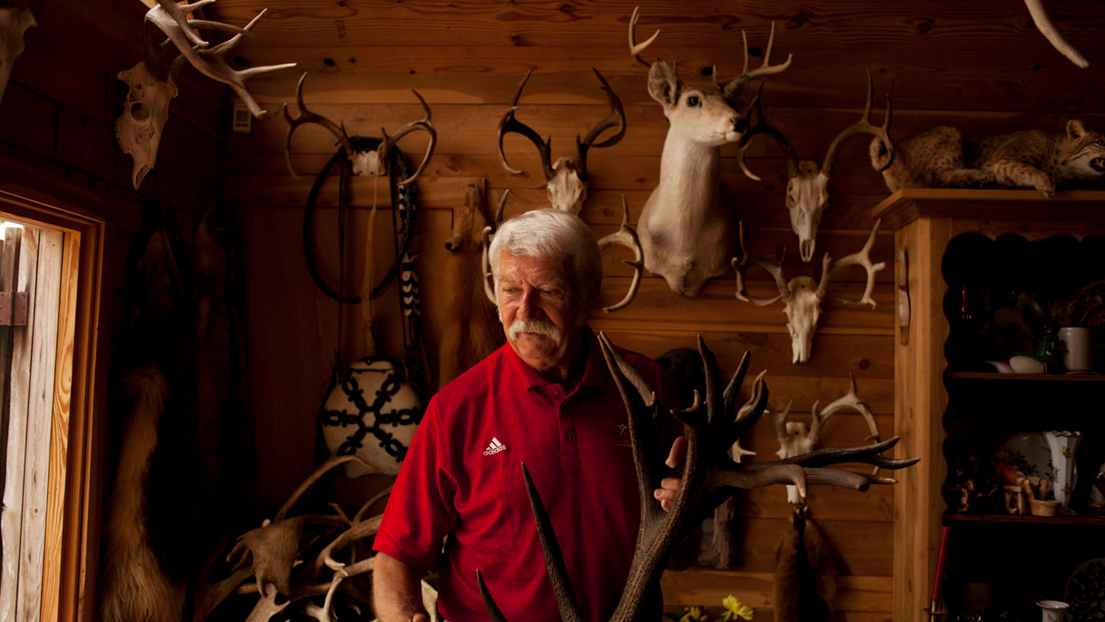 Bela Karolyi in his home. He is an avid hunter and his walls display many hunting trophies.