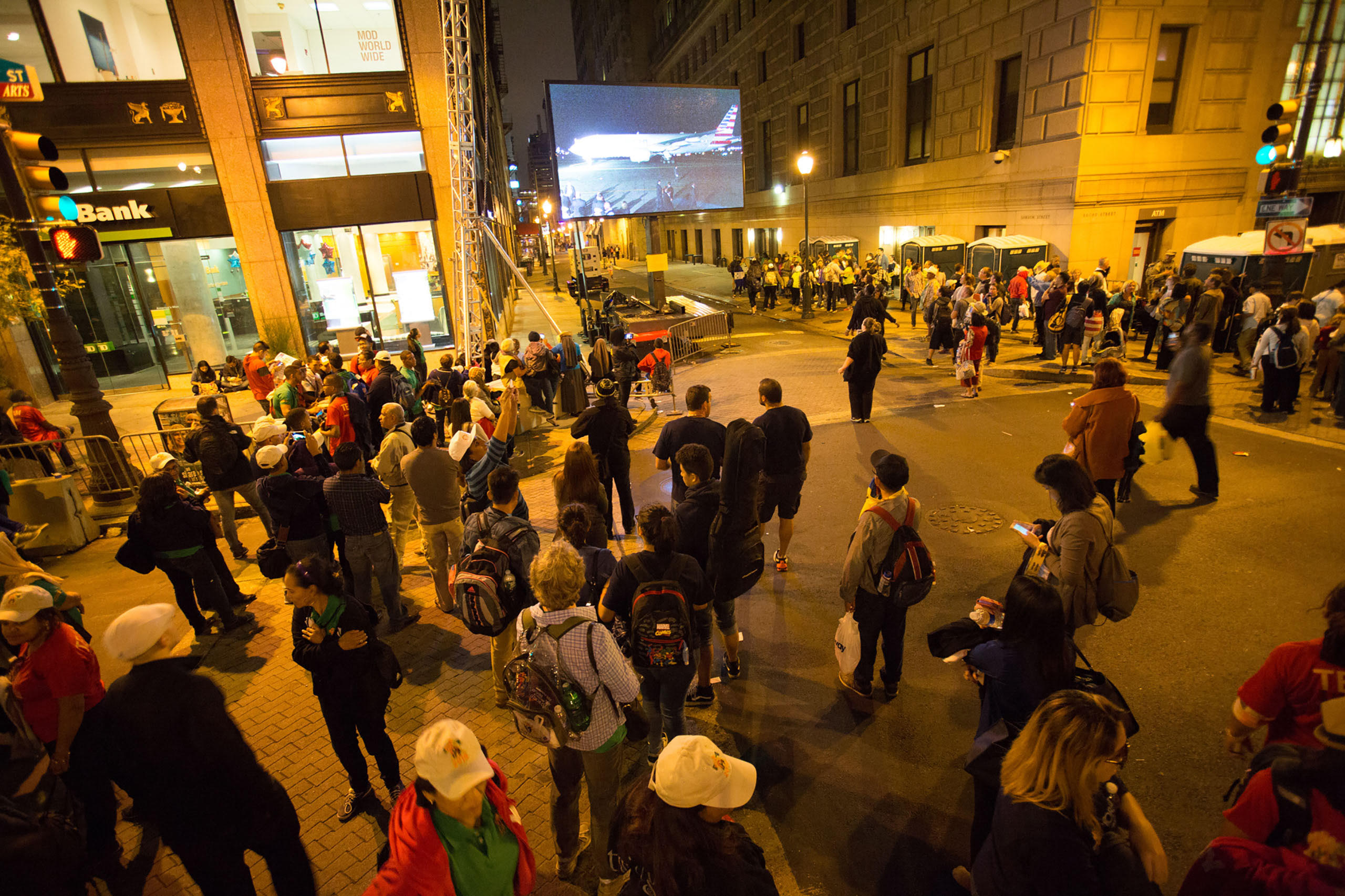 People watch the departure of Pope Francis on a screen as he departs on a plane at Philadelphia International Airport on route to Rome. Philadelphia, PA. Sept, 27, 2015.