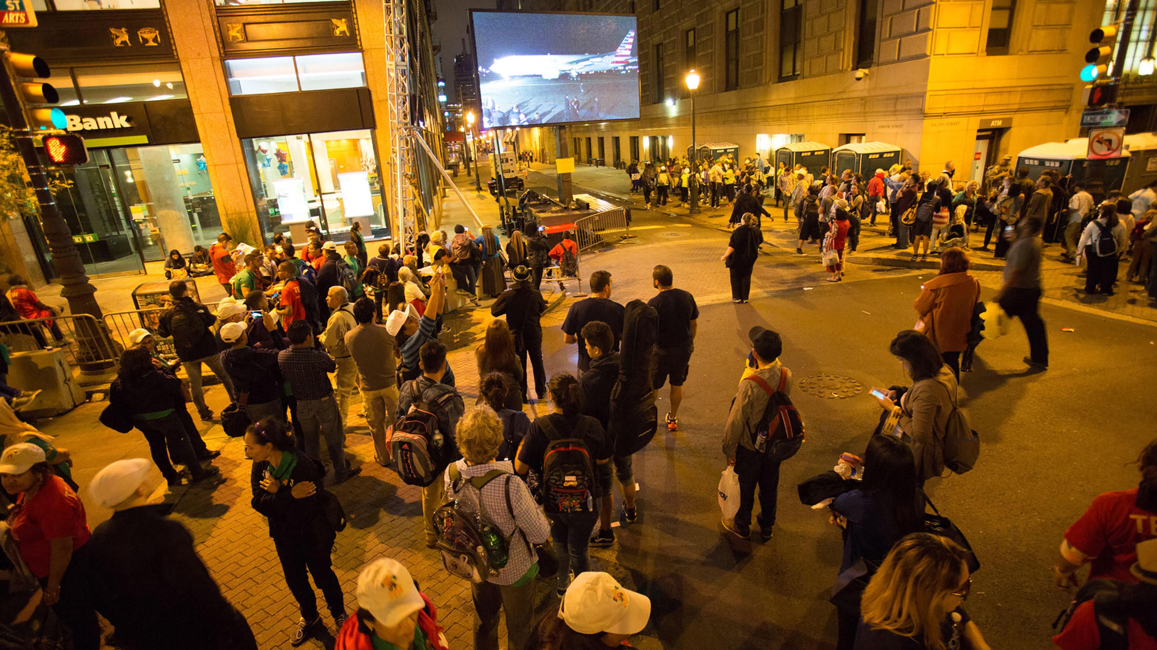 People watch the departure of Pope Francis on a screen as he departs on a plane at Philadelphia International Airport on route to Rome. Philadelphia, PA. Sept, 27, 2015.