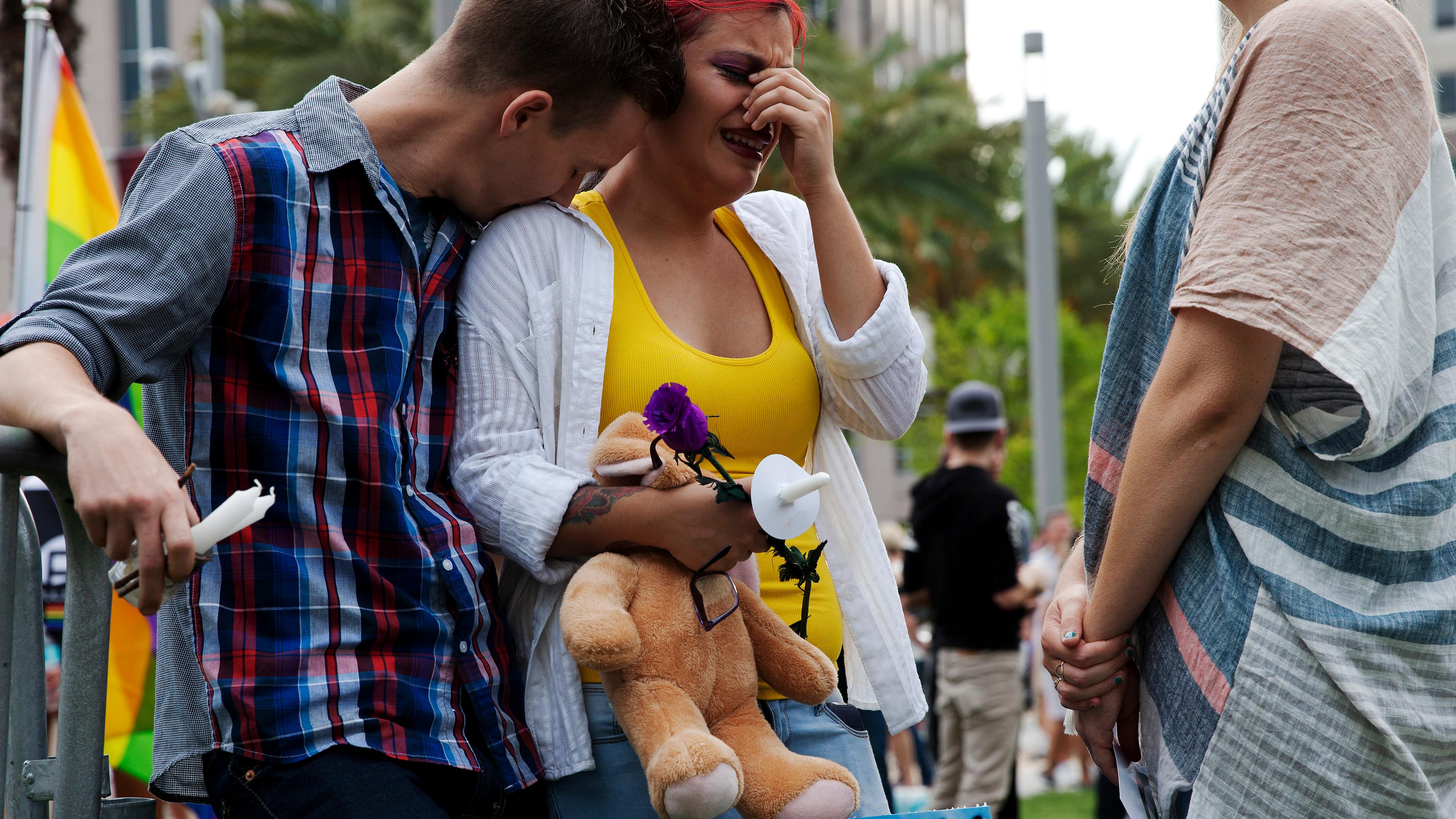 Mourners attend a makeshift vigil for victims of the Pulse nightclub shooting in Orlando, Fla., on June 13, 2016.