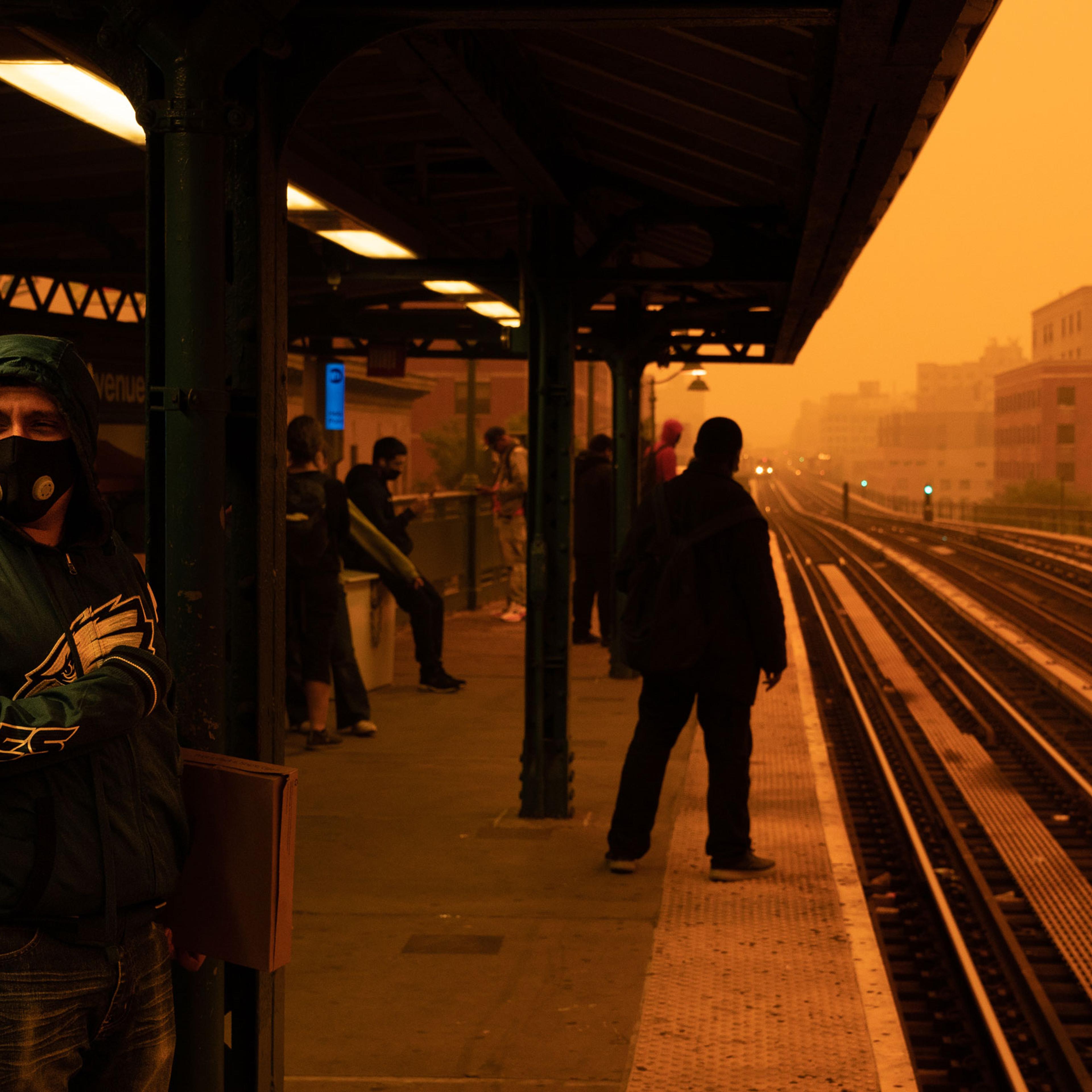 A person waiting for the subway wears a filtered mask as smoky haze from wildfires in Canada blankets a neighborhood on June 7, 2023 in the Bronx borough of New York City.