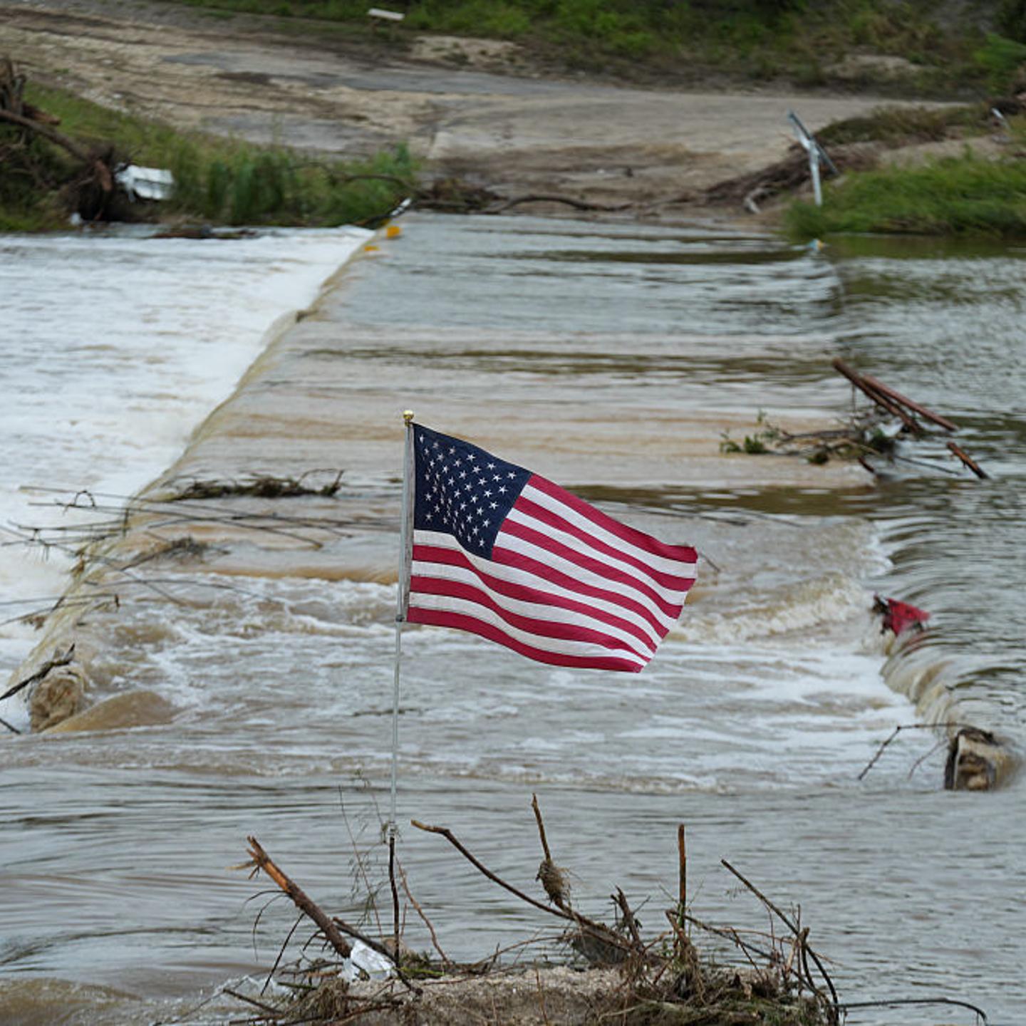A U.S. flag is seen around the Guadalupe River, which overflowed, contributing to a disaster that has killed over 100 people in Texas in July 2025.