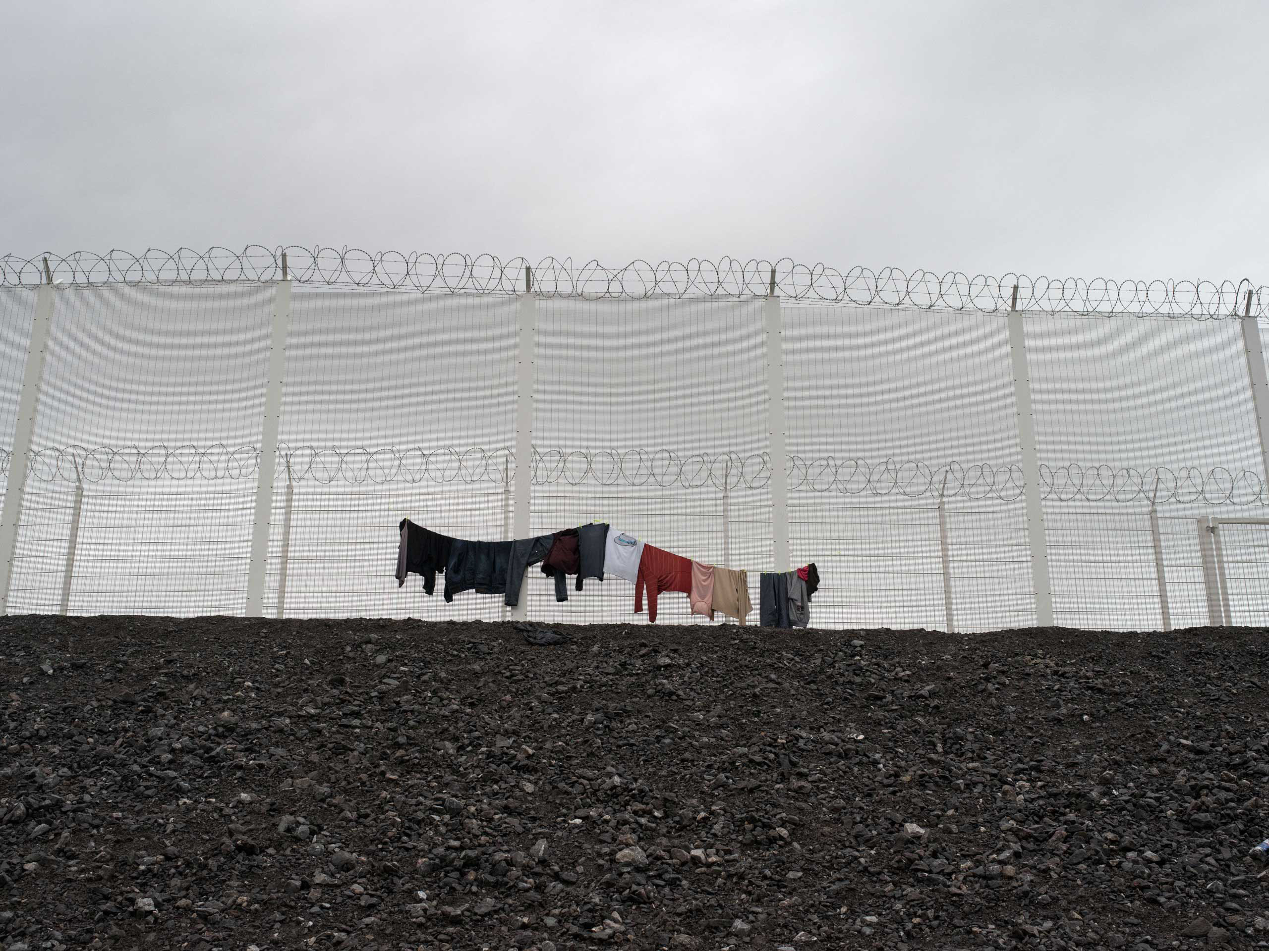 Clothes hang to dry on the fence of the Calais, France shantytown, known as the "jungle," Nov. 24, 2015.