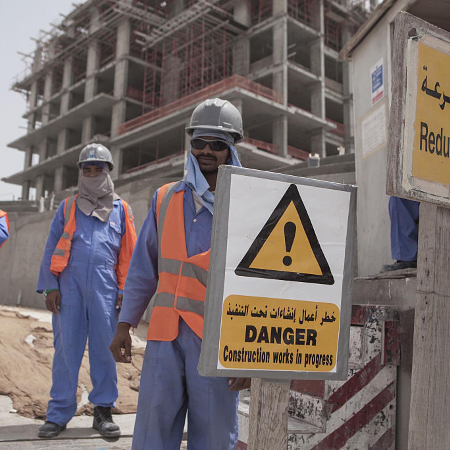 Migrant construction workers pose for a picture outside of their work site at The Pearl, a man-made chain of islands off the coast of northern Doha, which hosts dozens of high-rise luxury apartment complexes, villas, restaurants, and shops.