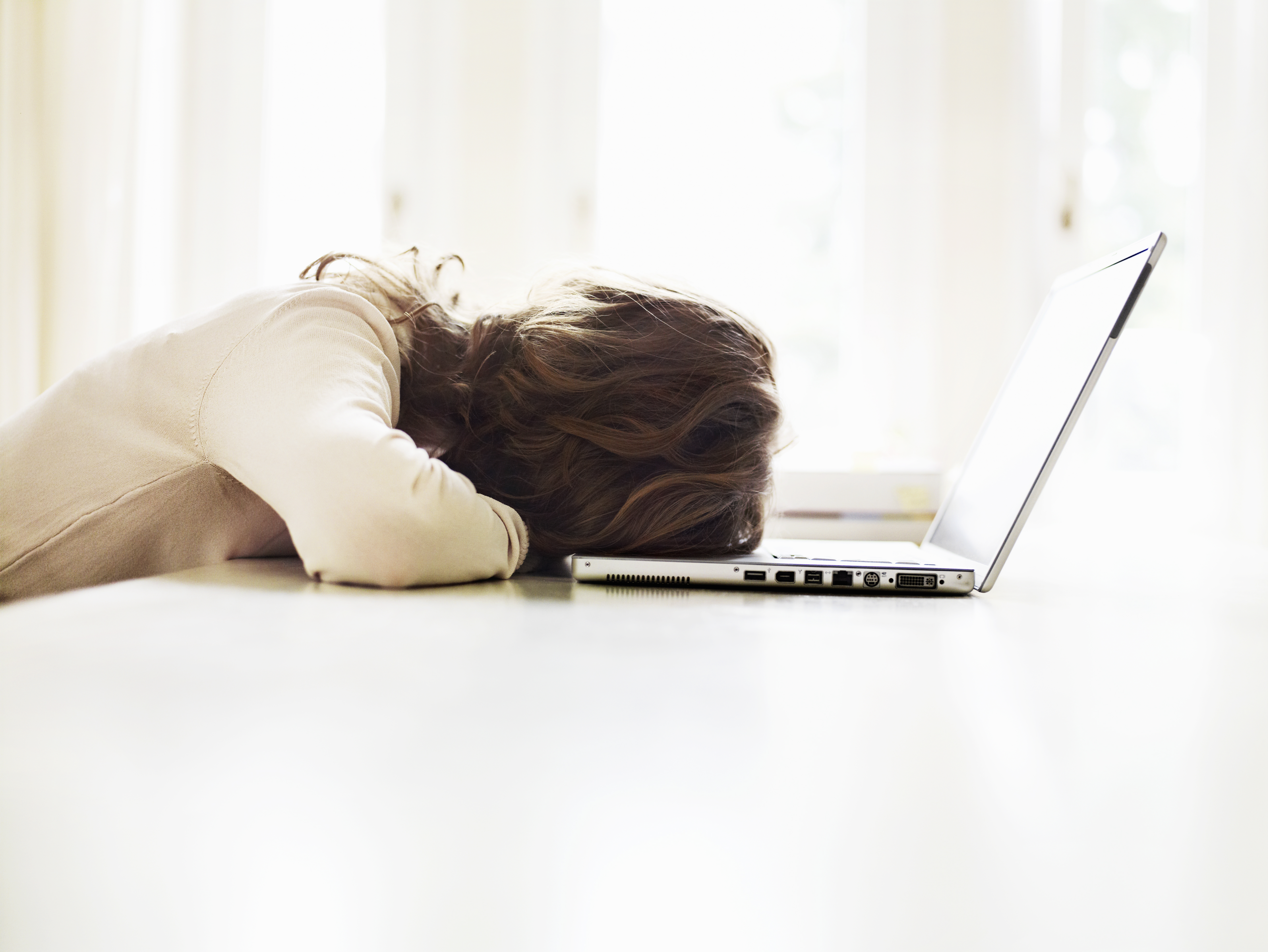 Teenage girl (16-17) lying on table with laptop, rear view TIME health stock