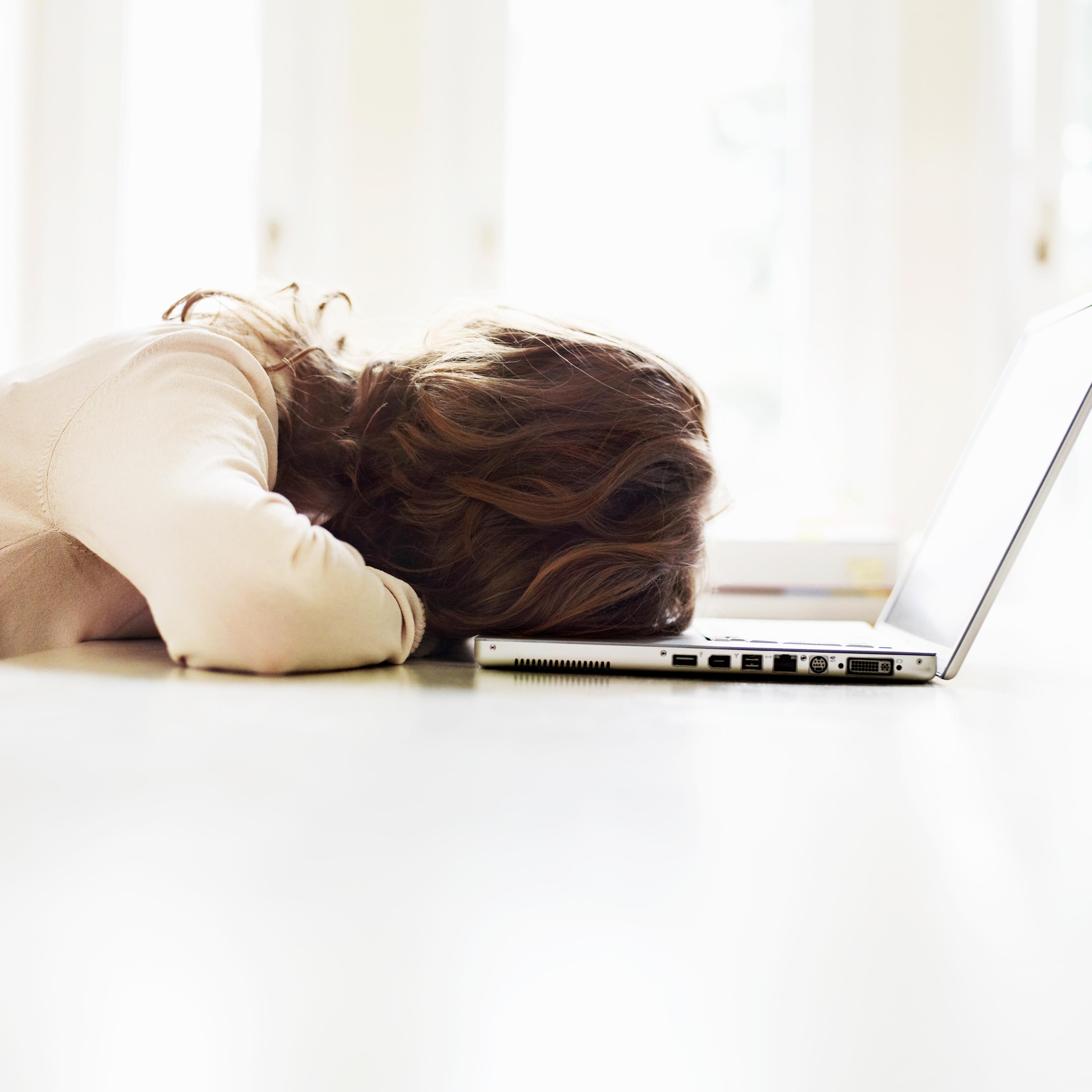 Teenage girl (16-17) lying on table with laptop, rear view TIME health stock