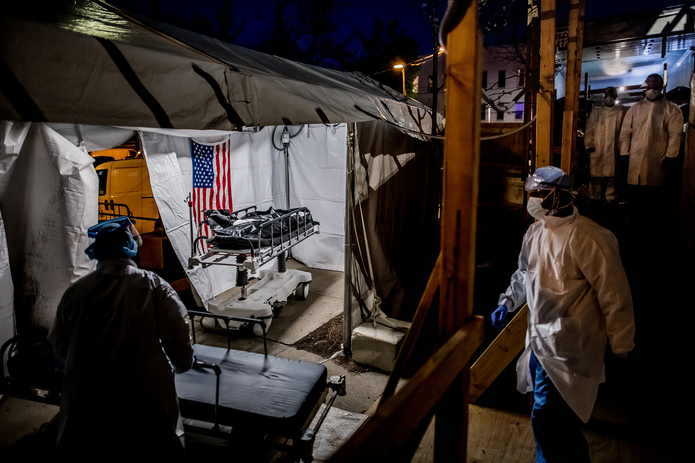 The transport team moves the body bags of deceased COVID-19 patients from the overflowing morgue of Brooklyn's Wyckoff Heights Medical Center into the improvised morgue set up outside on April 27. Three refrigerated semitrailers, capable of holding more 