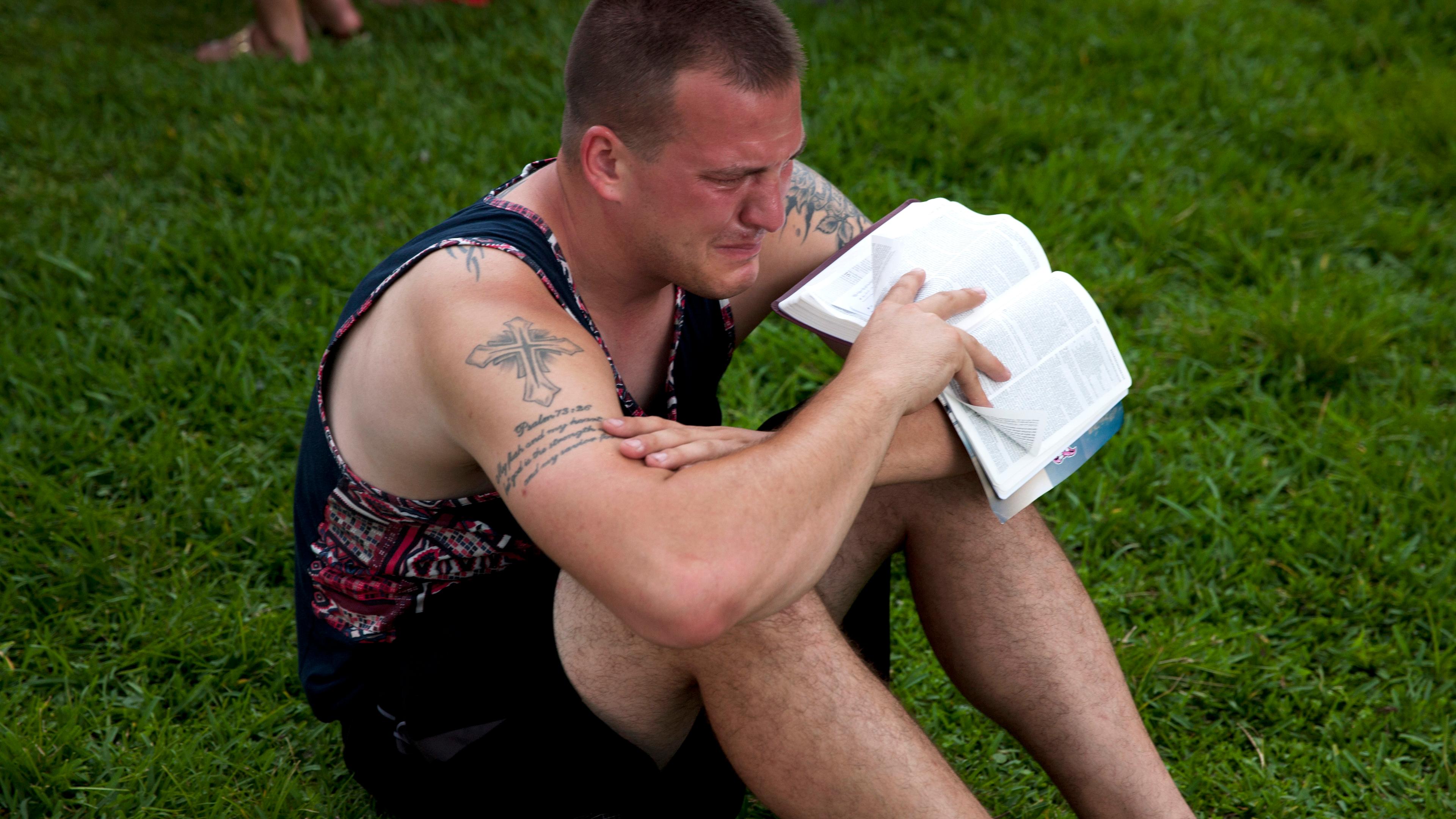 A mourner attends a makeshift vigil and a moment of silence for victims of the Pulse nightclub shooting in Orlando, Fla., on June 12, 2016.