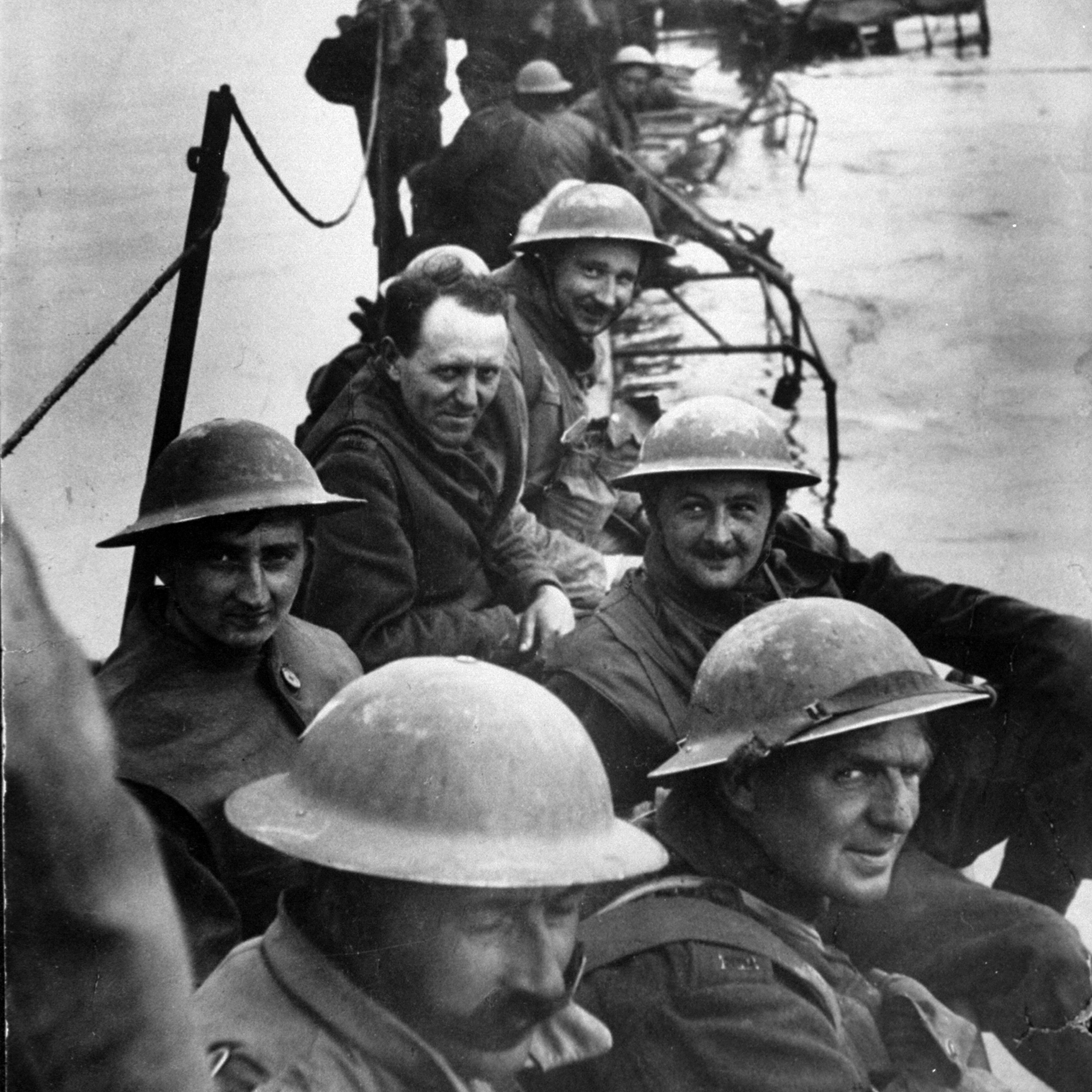 Members of Royal Ulster Rifles waiting on improvised pier of lorries to evacuate Dunkirk during low tide.